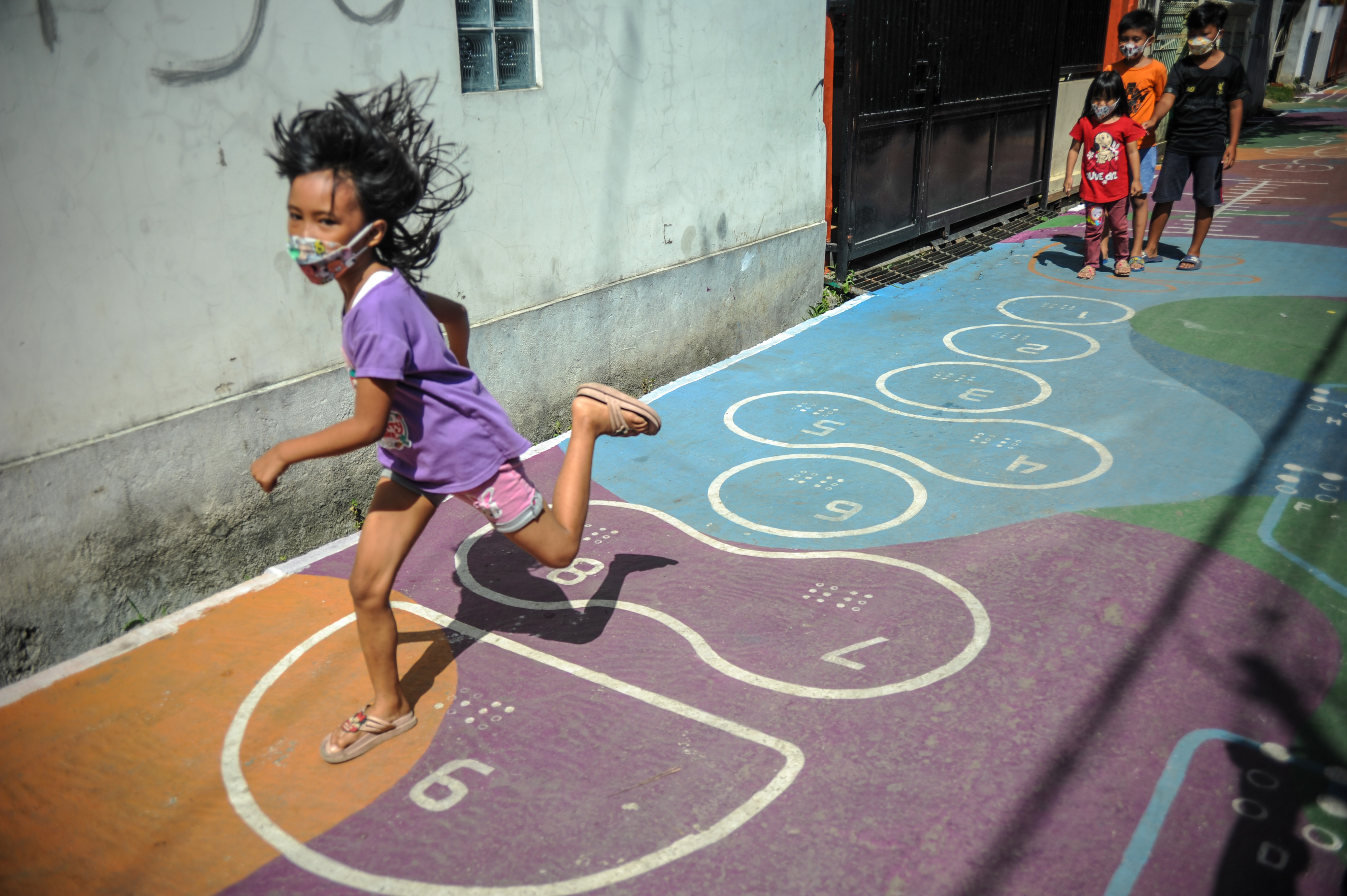 Sejumlah anak bermain permainan tradisional yang dilukis di Gang Sayuran 2, Jalan Gempolsari, Bandung, Jawa Barat.