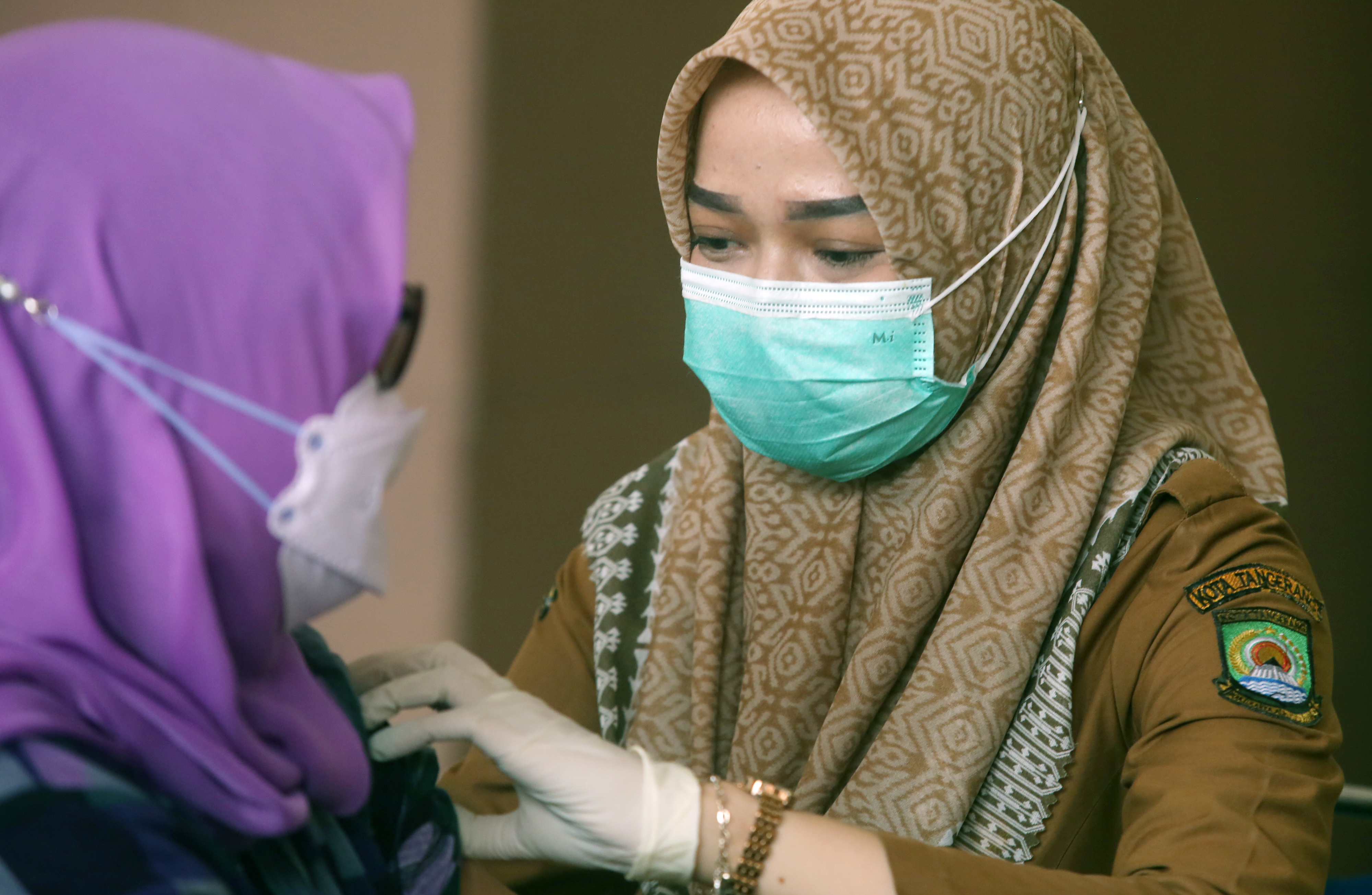 Petugas menyuntikkan vaksin covid-19 dosis ketiga pada seorang ASN di Puspem Kota Tangerang, Tangerang, Banten, Selasa (18/1/2022)