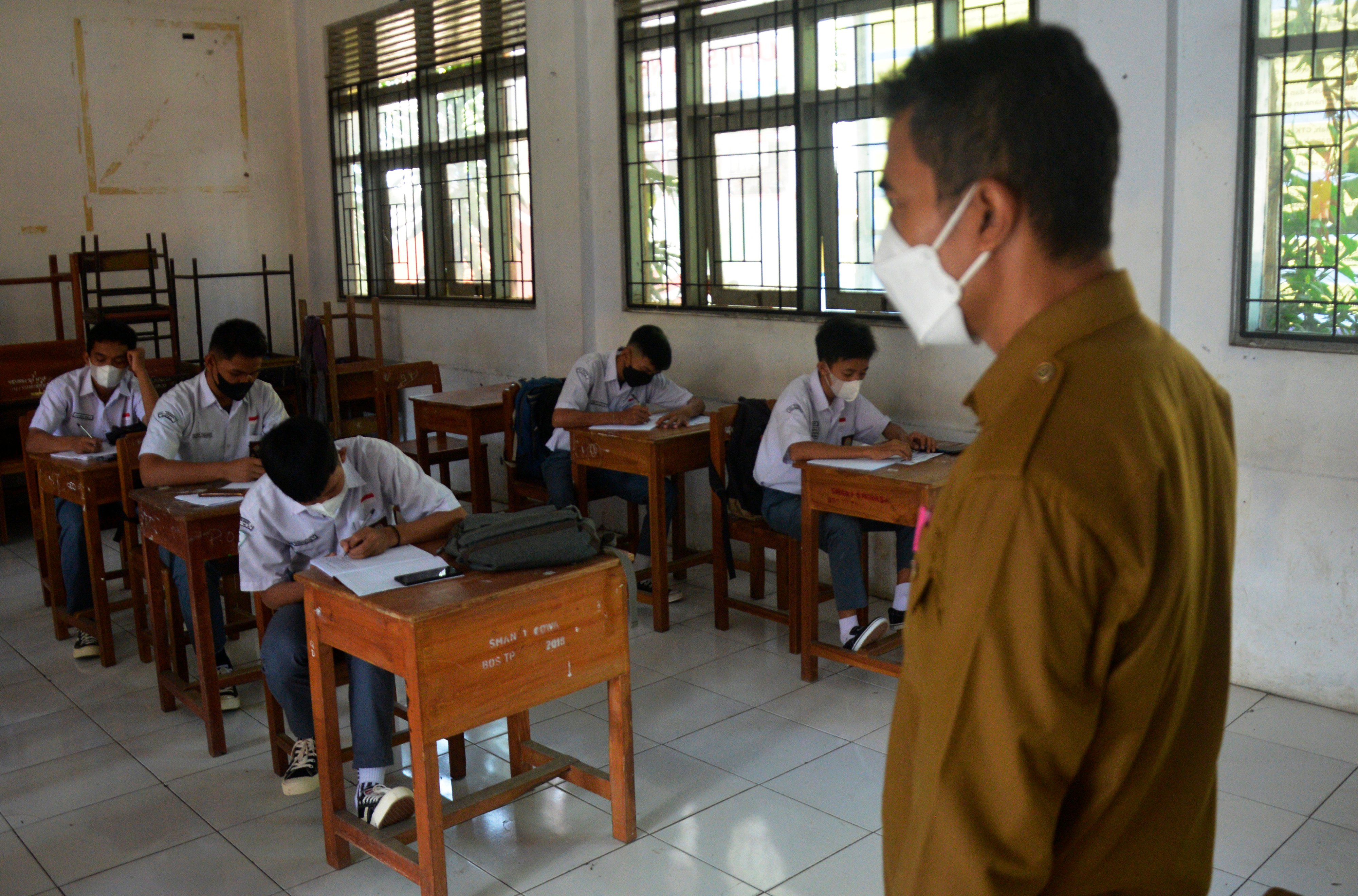Seorang guru memberikan materi pelajaran saat pembelajaran tatap muka terbatas di SMA Negeri 1, Kabupaten Gowa, Sulawesi Selatan.