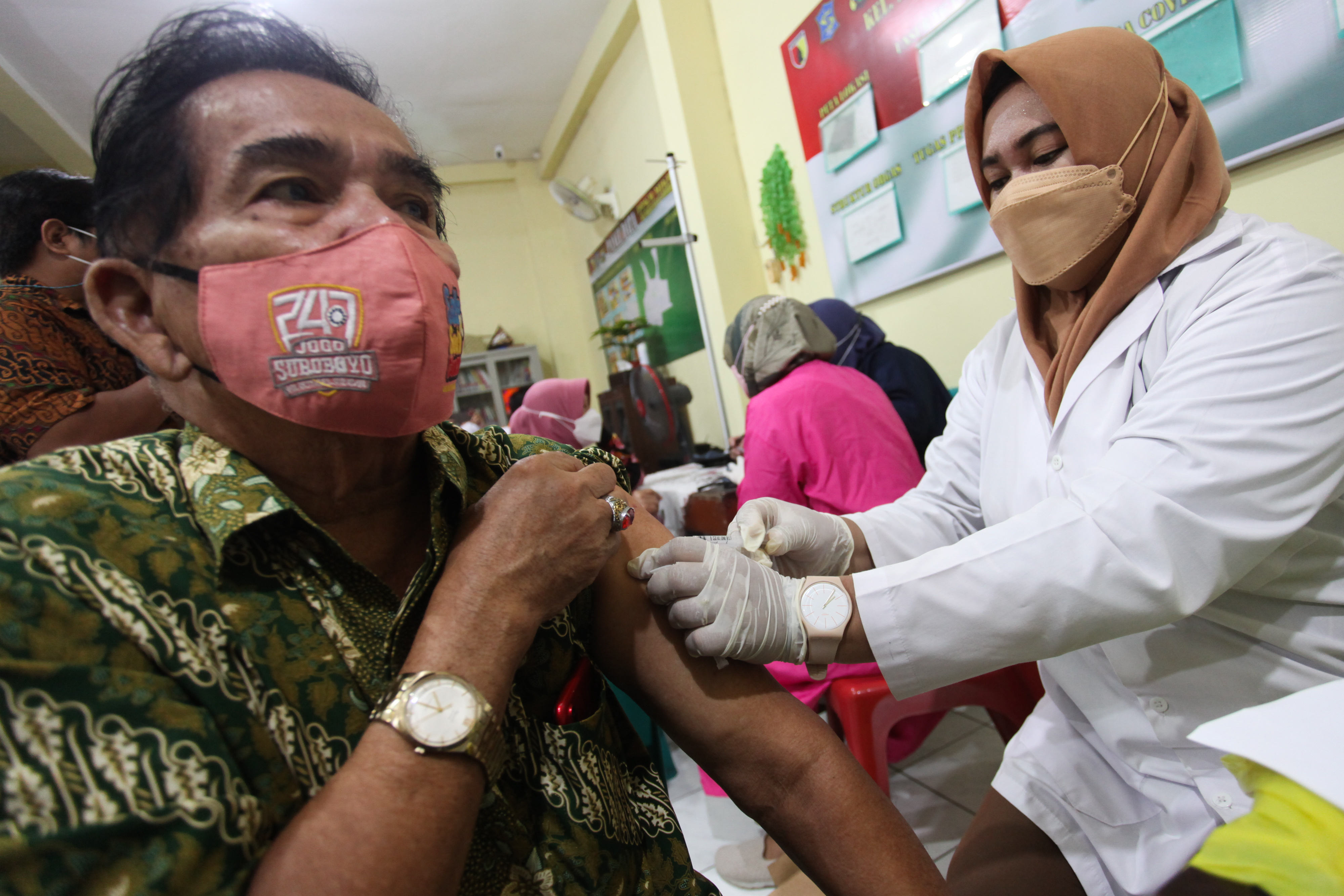 VAKSINASI LANJUTAN: Petugas menyuntikkan vaksin covid-19 dosis ketiga (booster) kepada warga lansia di kawasan Ngagel Mulyo, Surabaya.