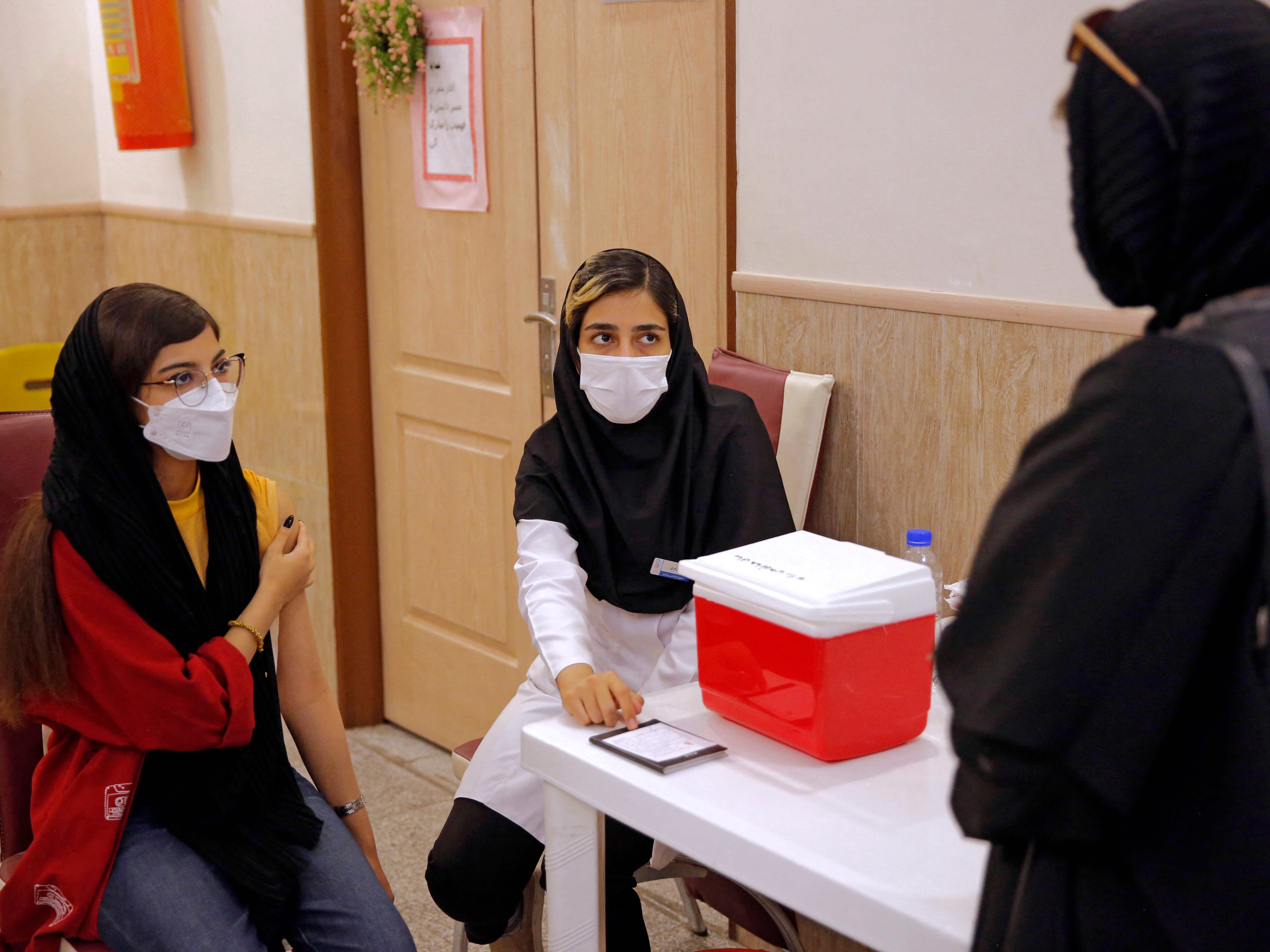 Seorang siswa menerima dosis vaksin covid-19 di pusat vaksinasi yang didirikan dalam sekolah di ibu kota Iran, Teheran.