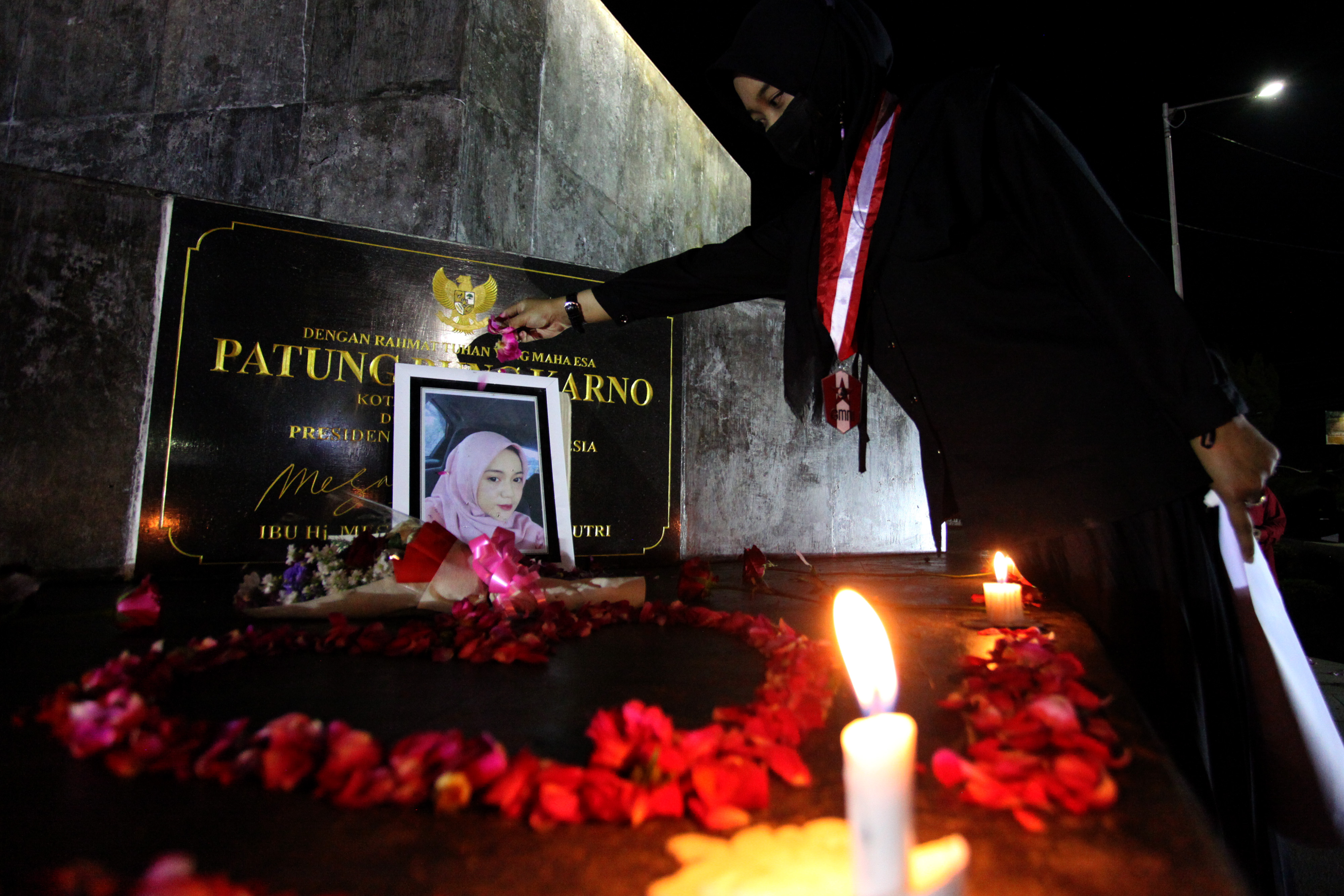 Peserta aksi menaburkan bunga di atas foto almarhumah Novia Widyasari.