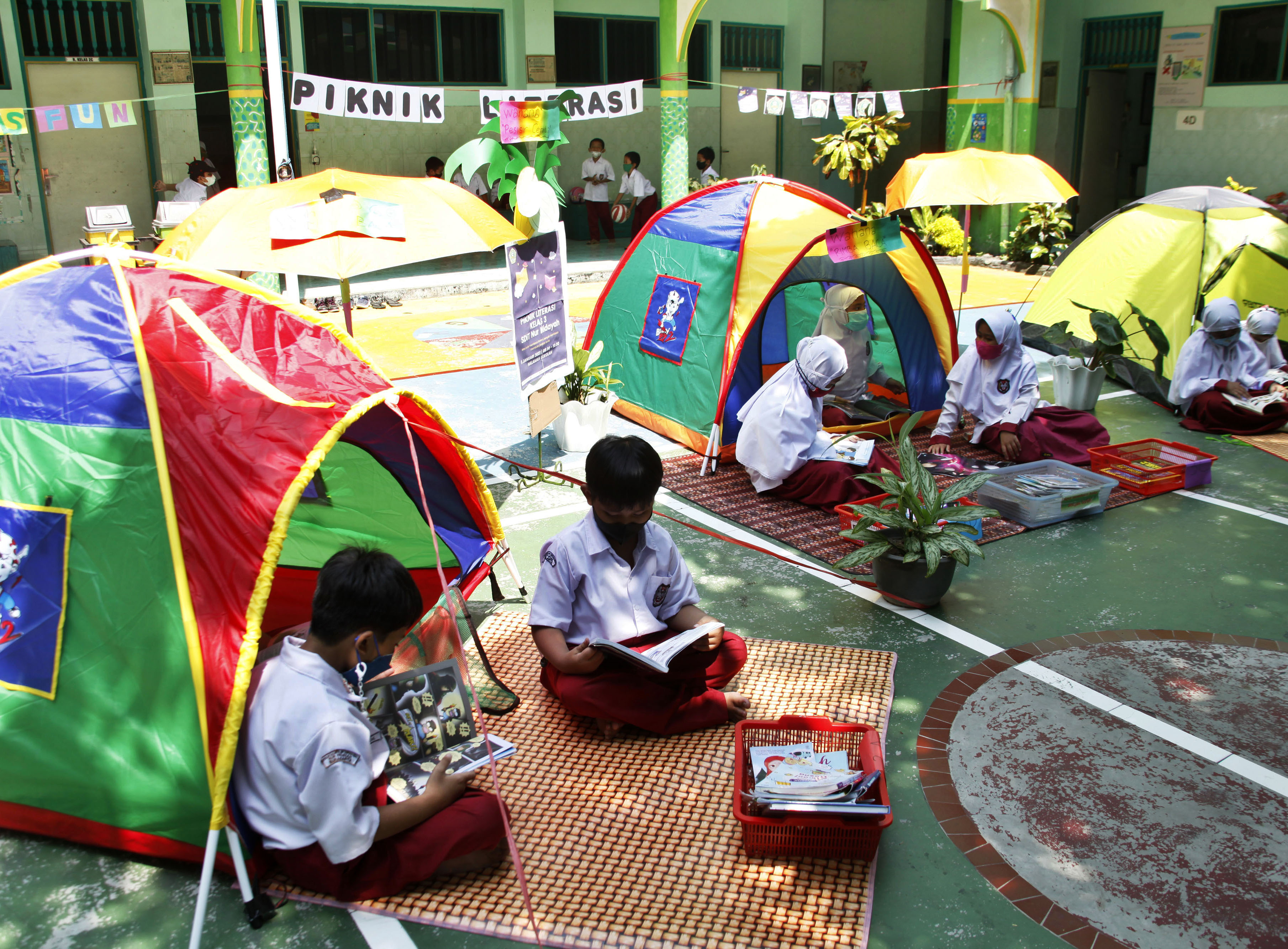 PIKNIK LITERASI: Siswa SD Islam Terpadu Nur Hidayah Solo membaca buku bersama saat mengikuti Piknik Literasi di halaman sekolah, Kamis (6/1)
