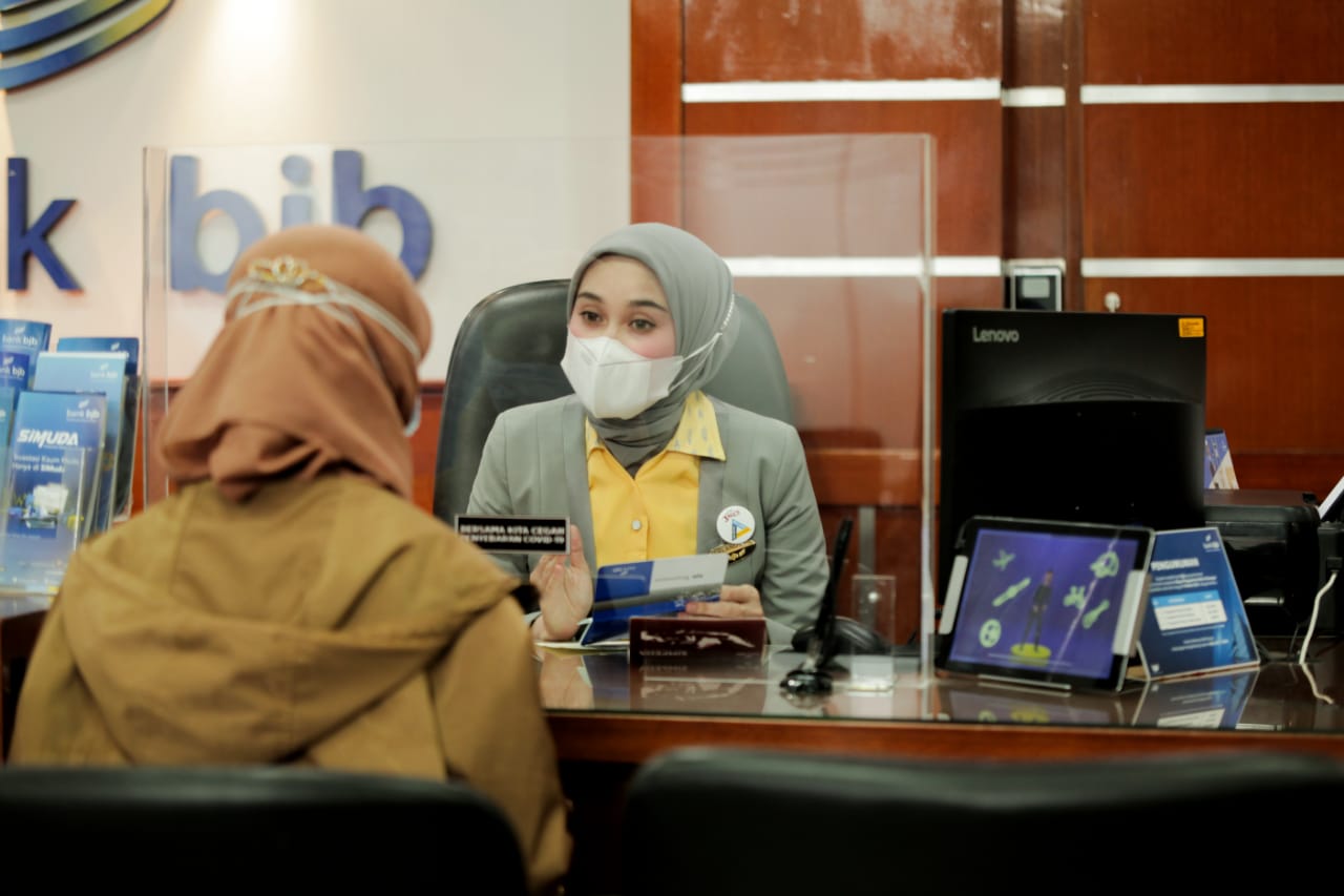 Staf customer service bank bjb memberi pelayanan kepada nasabah. 