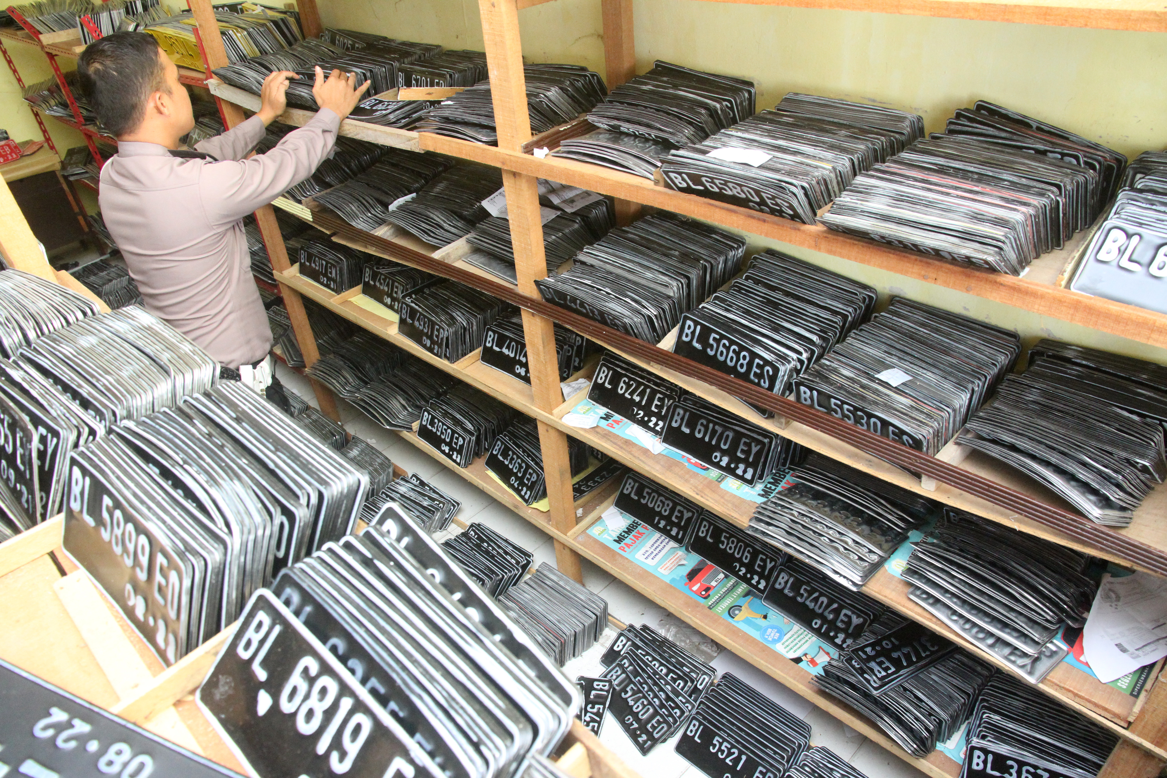 Petugas kepolisian menata pelat Tanda Nomor Kendaraan Bermotor (TNKB) di gudang Samsat Aceh Barat, Aceh.