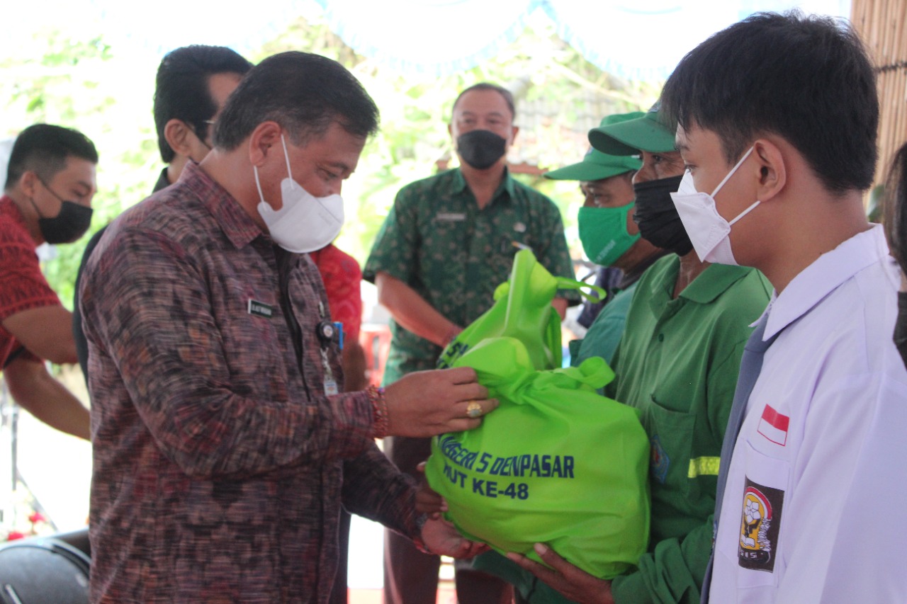 Sekda Kota Denpasar IB Alit Wiradana menyerahkan bantuan paket sembako dari SMAN 5 Denpasar 