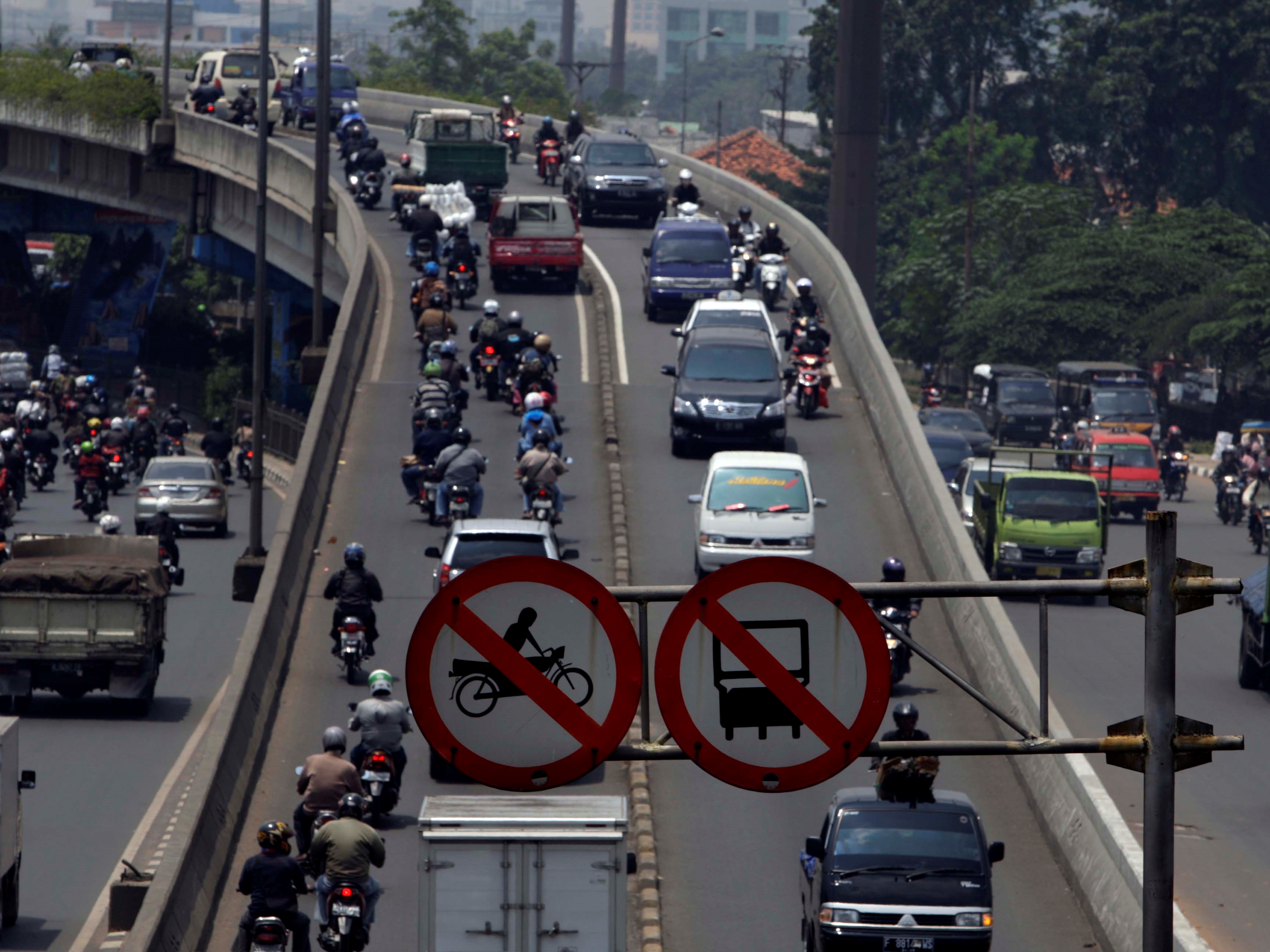 Sejumlah pengendara sepeda motor memasuki jalan fly over Pesing, Jakarta Barat.