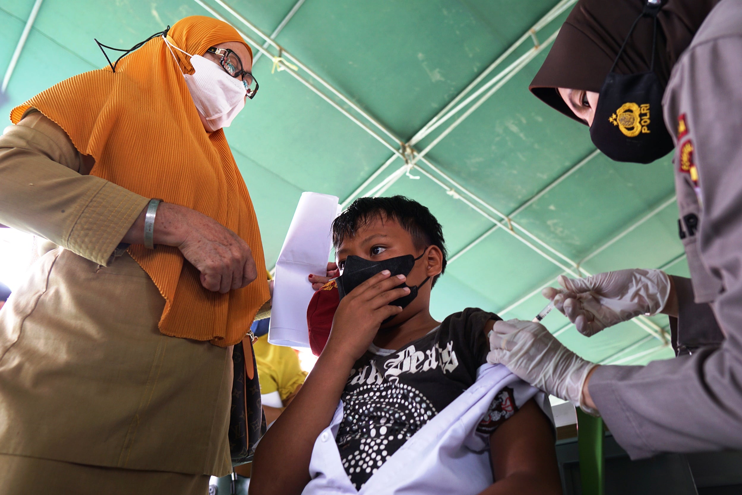 Ilustrasi vaksinasi oleh personel Polri.