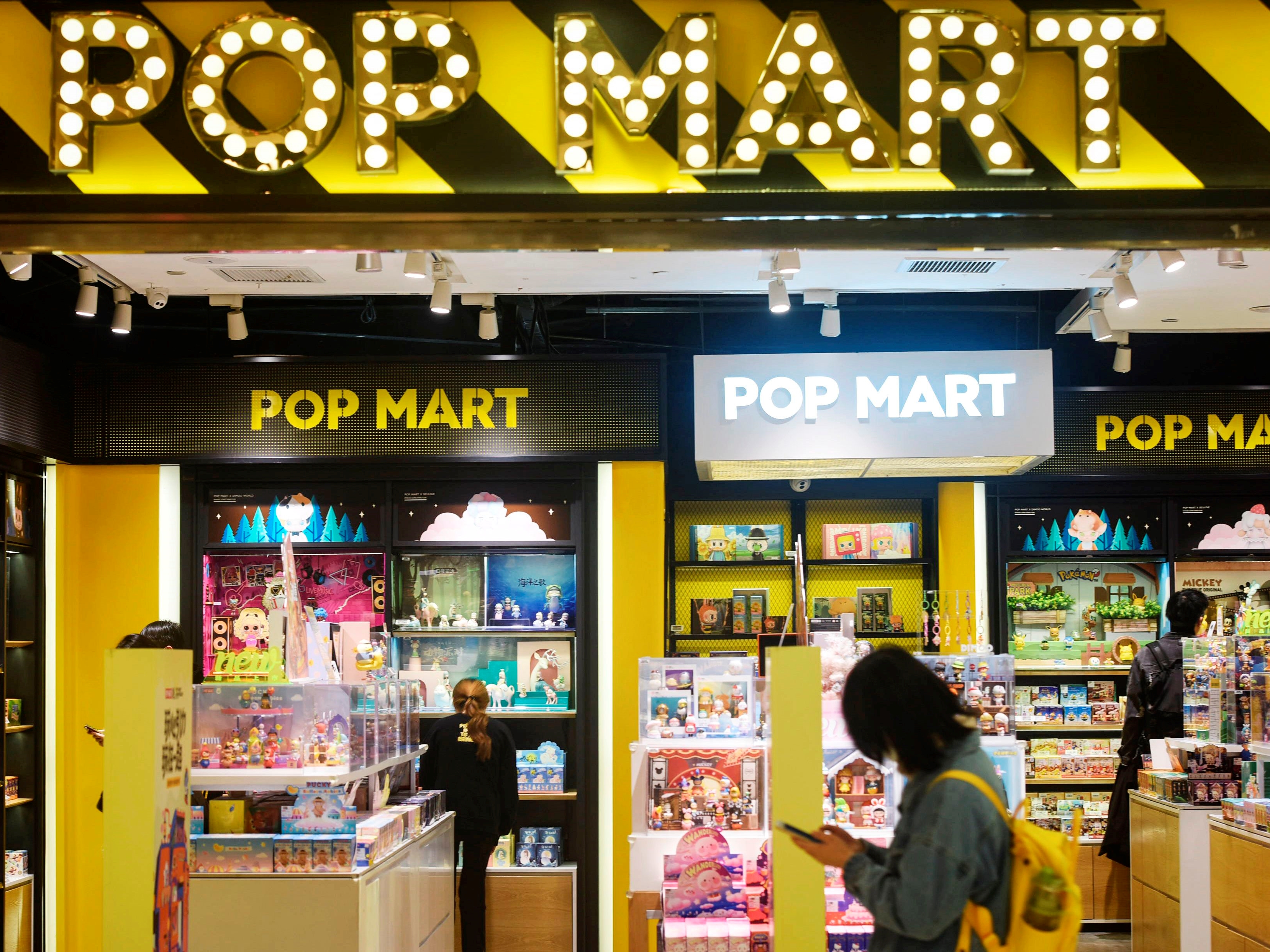 Seorang wanita berjalan melewati toko Pop Mart di Hangzhou di Provinsi Zhejiang, Tiongkok timur, pada 11 Desember 2020.