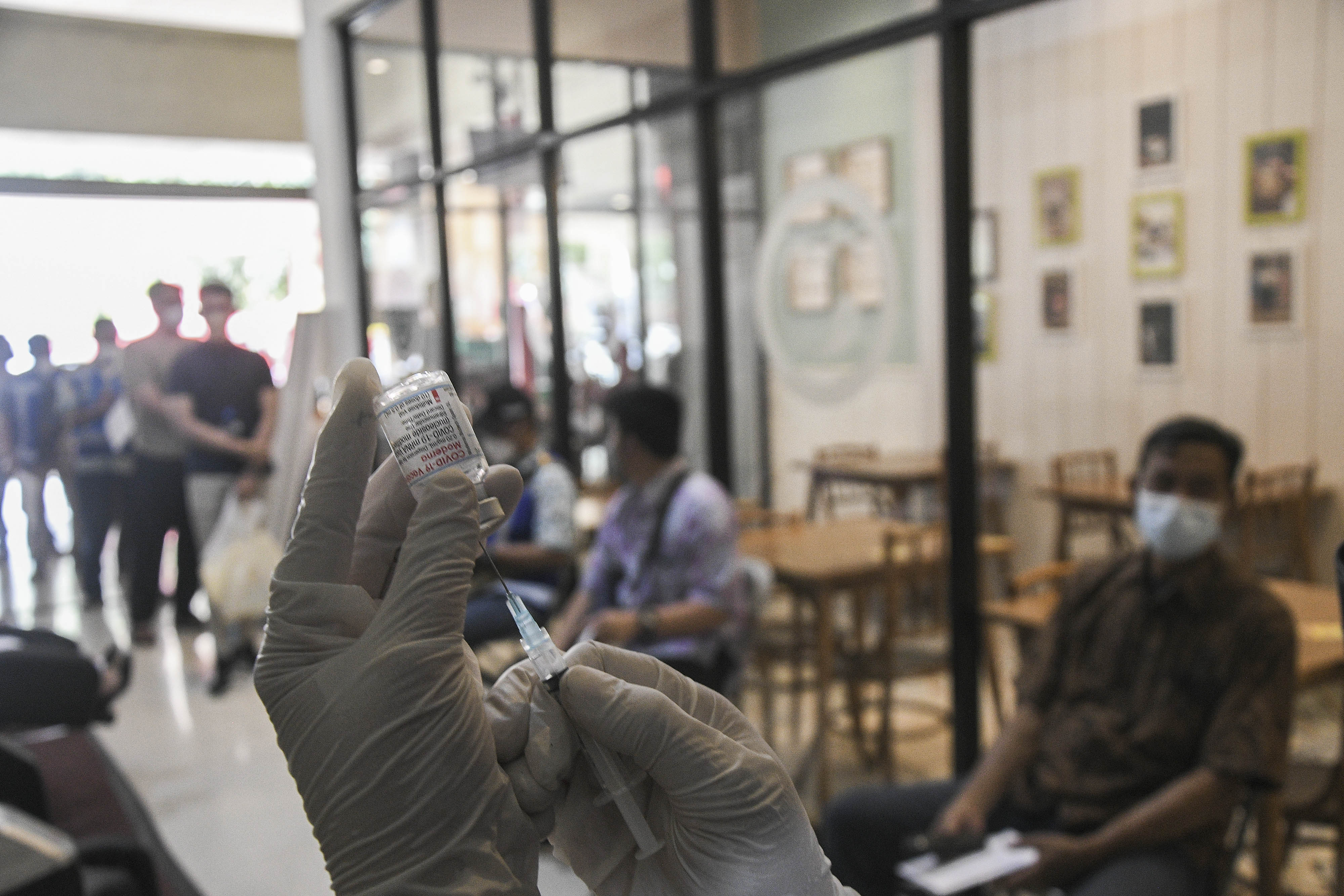 Petugas medis menyiapkan vaksin COVID-19 penguat (booster) jenis Moderna di rest area km 19, Tambun, Kabupaten Bekasi, Jawa Barat.