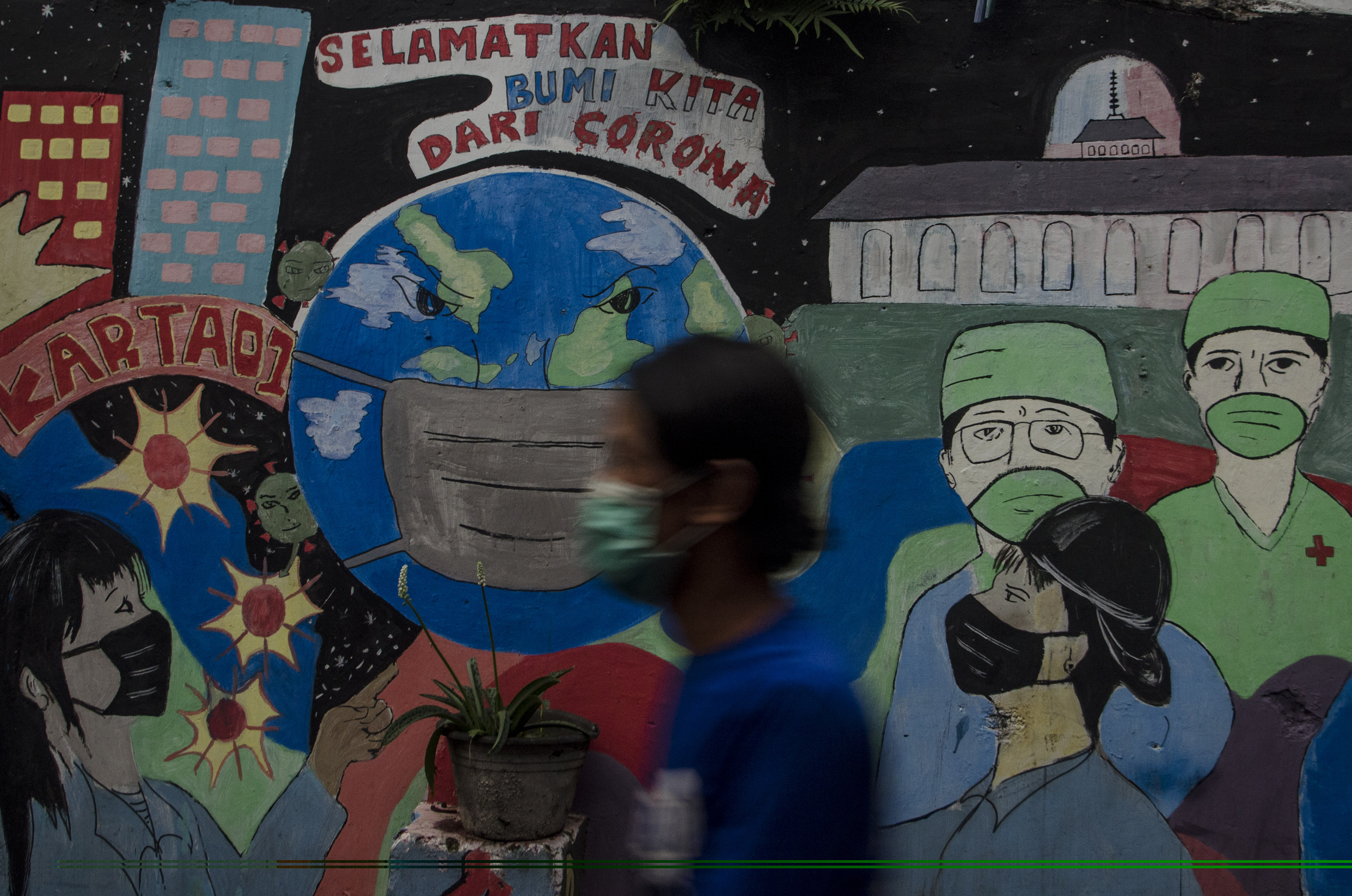 Warga melintasi mural bertema COVID-19 di Kota Bandung, Jawa Barat.