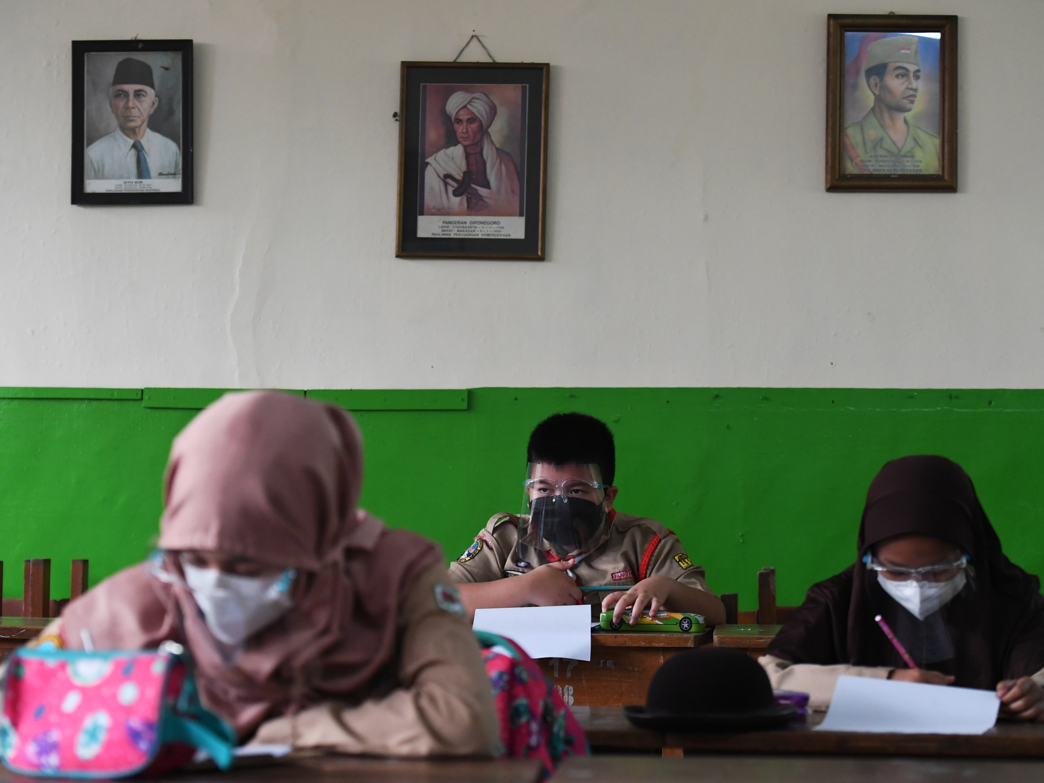 Sejumlah murid mengerjakan soal PAT saat menjalani uji coba PTM tahap dua di SDN Kebayoran Lama Selatan 17 Pagi, Jakarta.