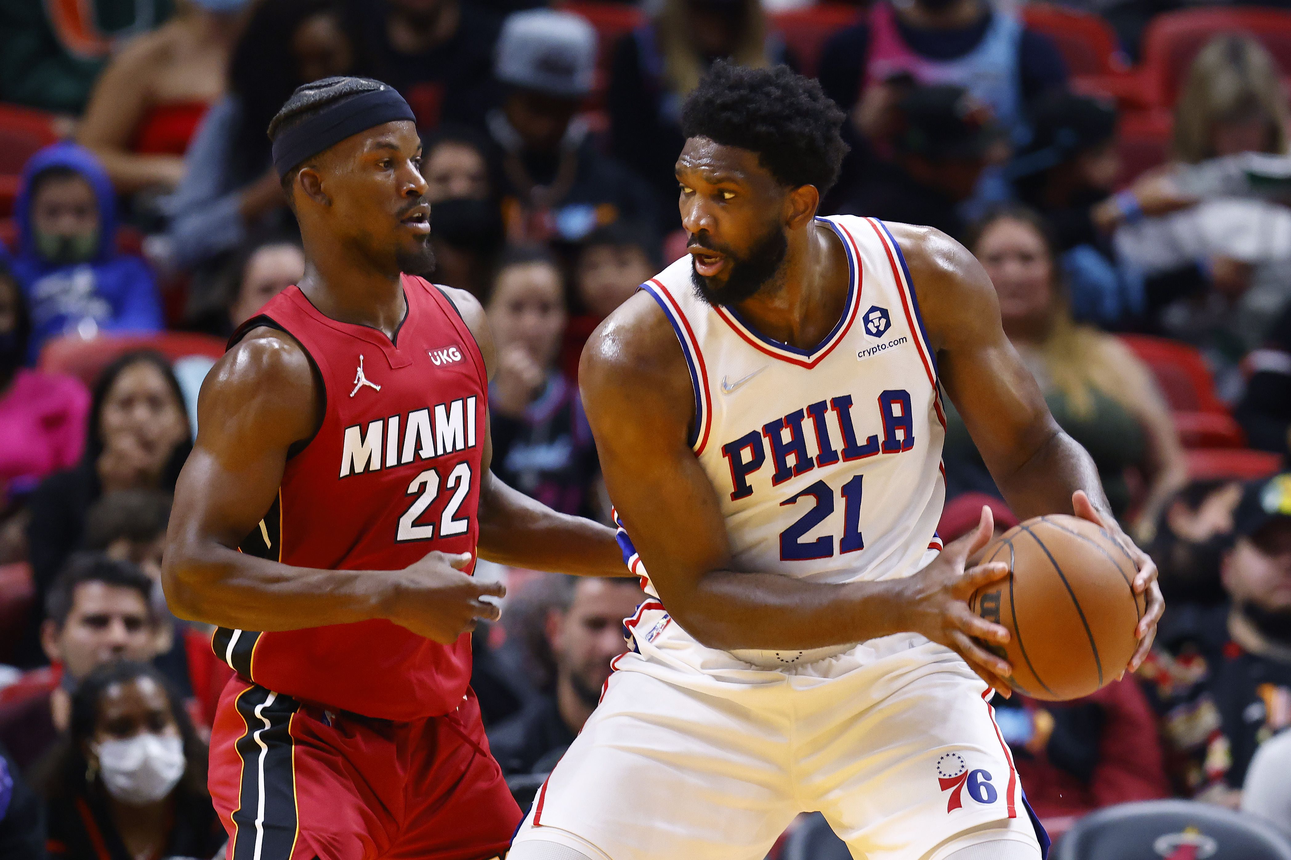 Pemain Philadelphia 76ers, Joel Embiid (kanan), mencoba melepas dari gangguan Jimmy Butler dari Miami Heat. 