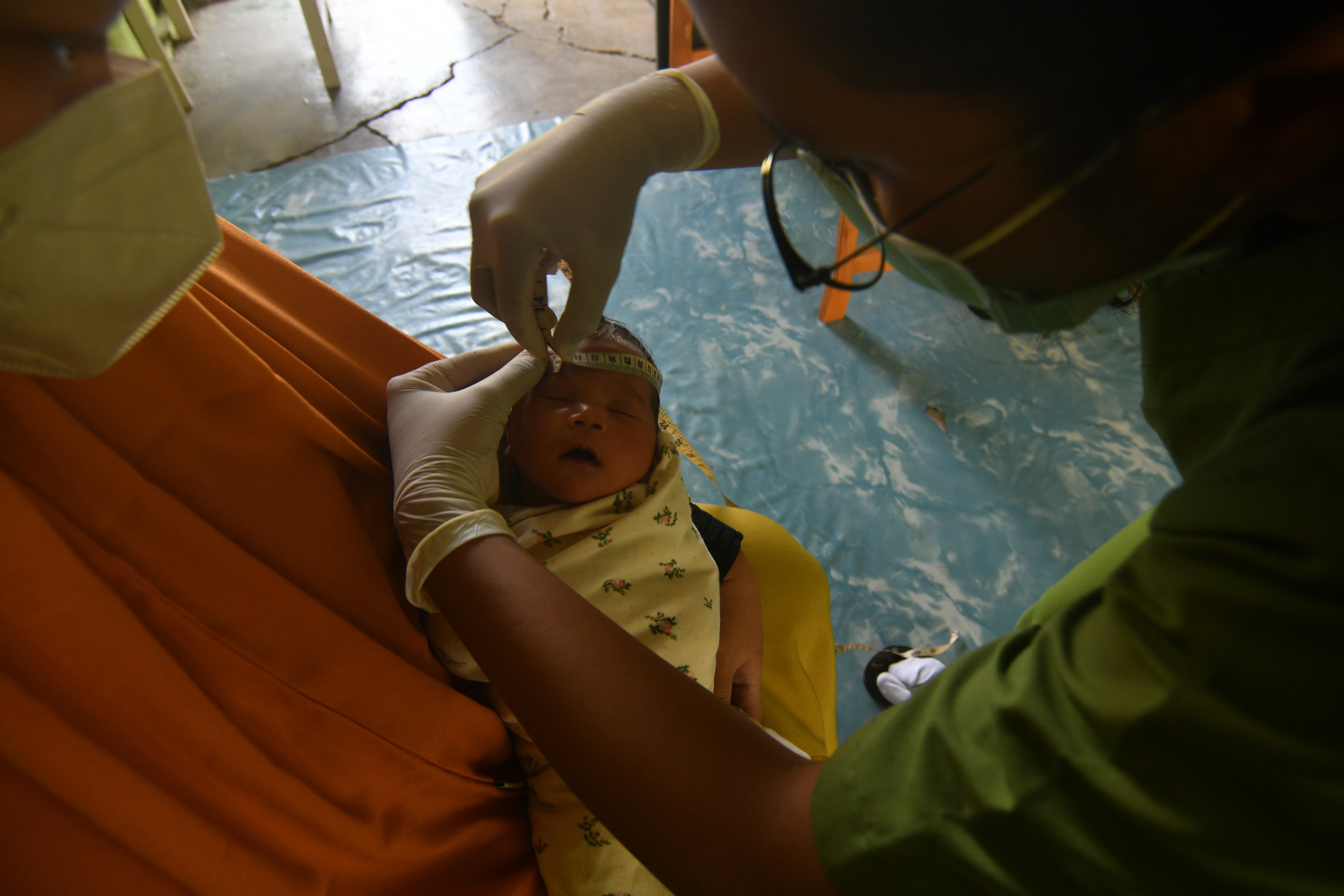 Tenaga kesehatan mengukur lingkar kepala bayi untuk mendeteksi stunting