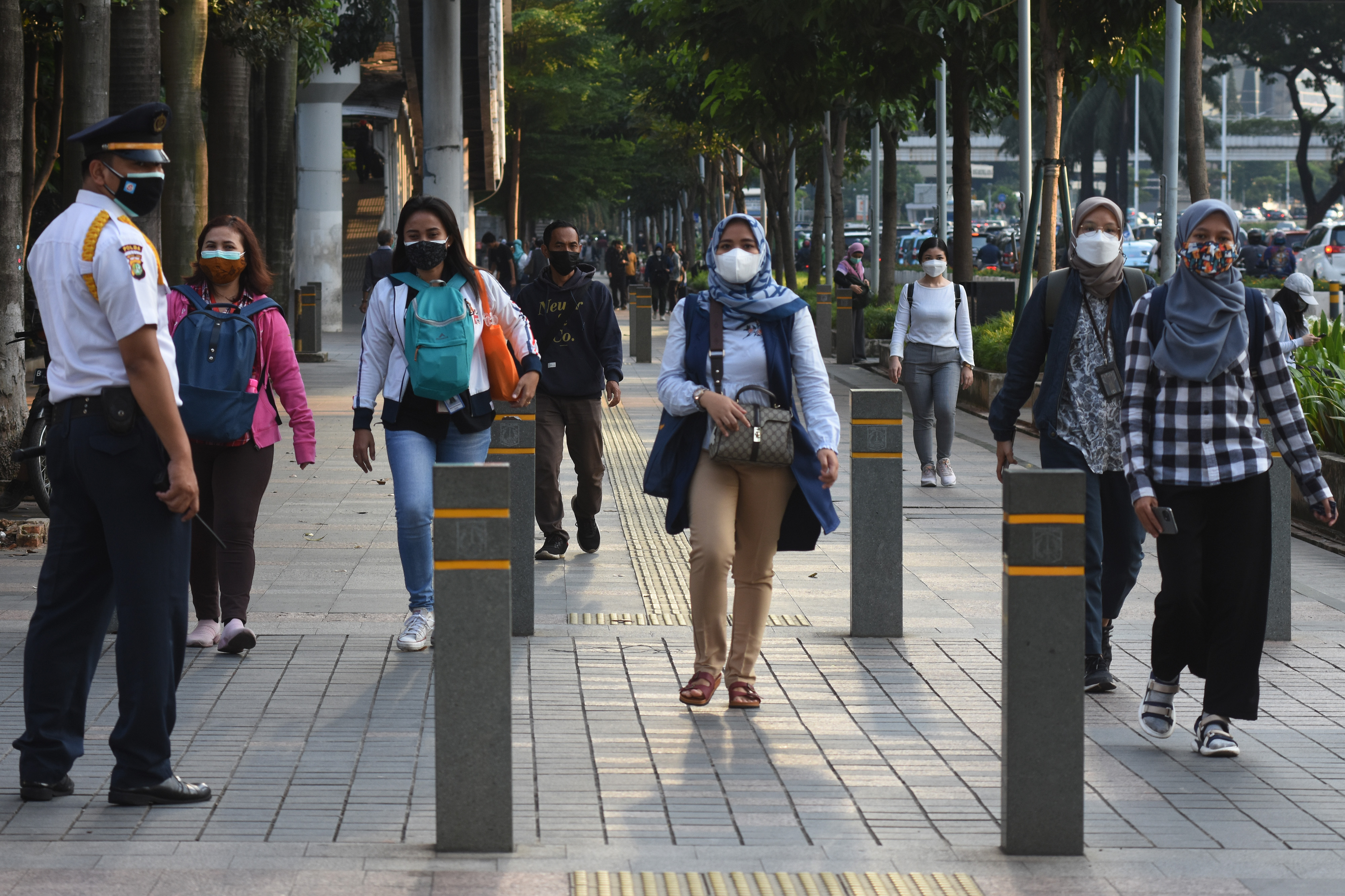 Pekerja melintas di jalur pedestrian Dukuh Atas, Jakarta saat jam pulang kerja