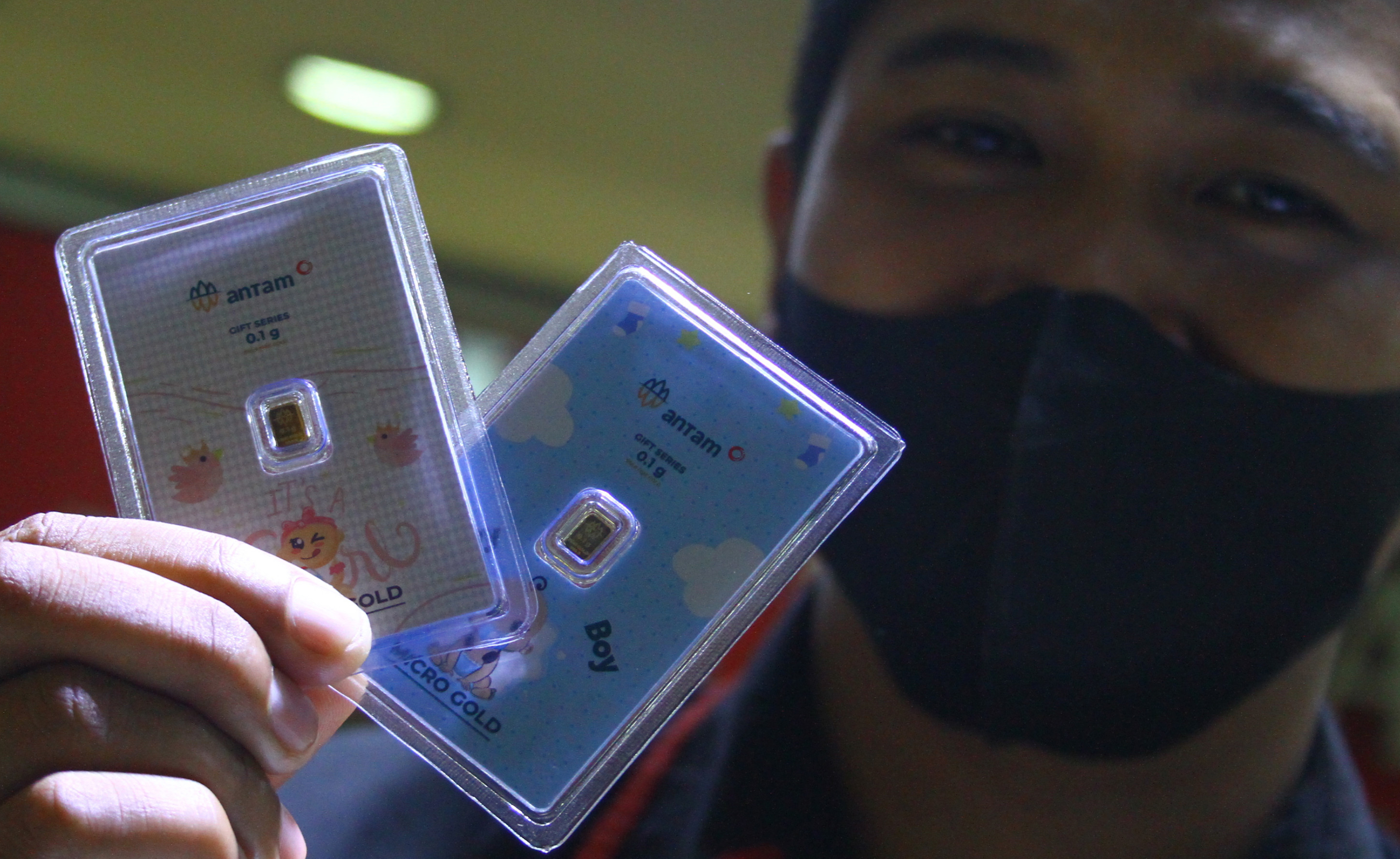 Pramuniaga menunjukkan emas mikro atau emas batangan yang berukuran 0,1 gram di sebuah gerai emas di Malang, Jawa Timur.