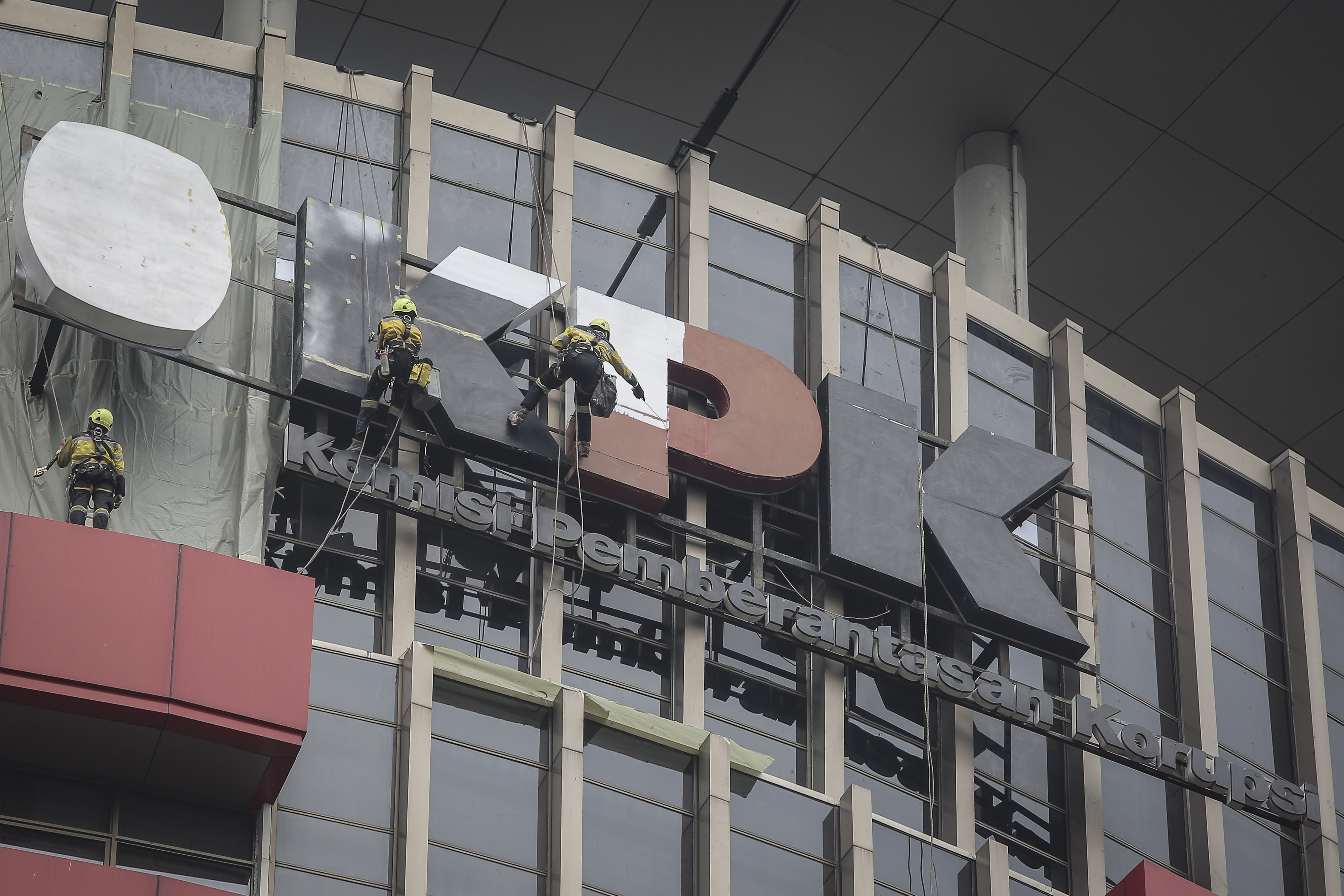 Sejumlah pekerja mengecat logo KPK yang terpasang di Gedung Merah Putih, Jakarta.
