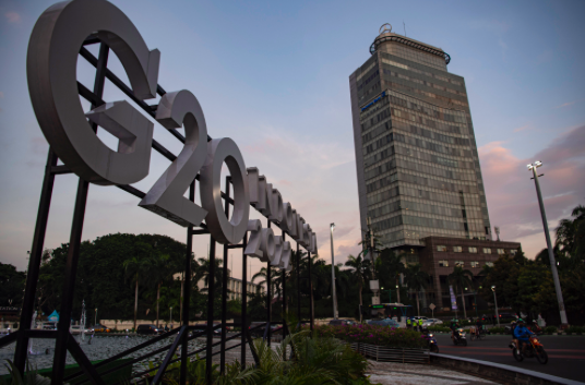 Pengendara motor melintas di samping logo Presidensi G20 Indonesia 2022 di Bundaran HI, Jakarta, Jumat (21/1/2022)