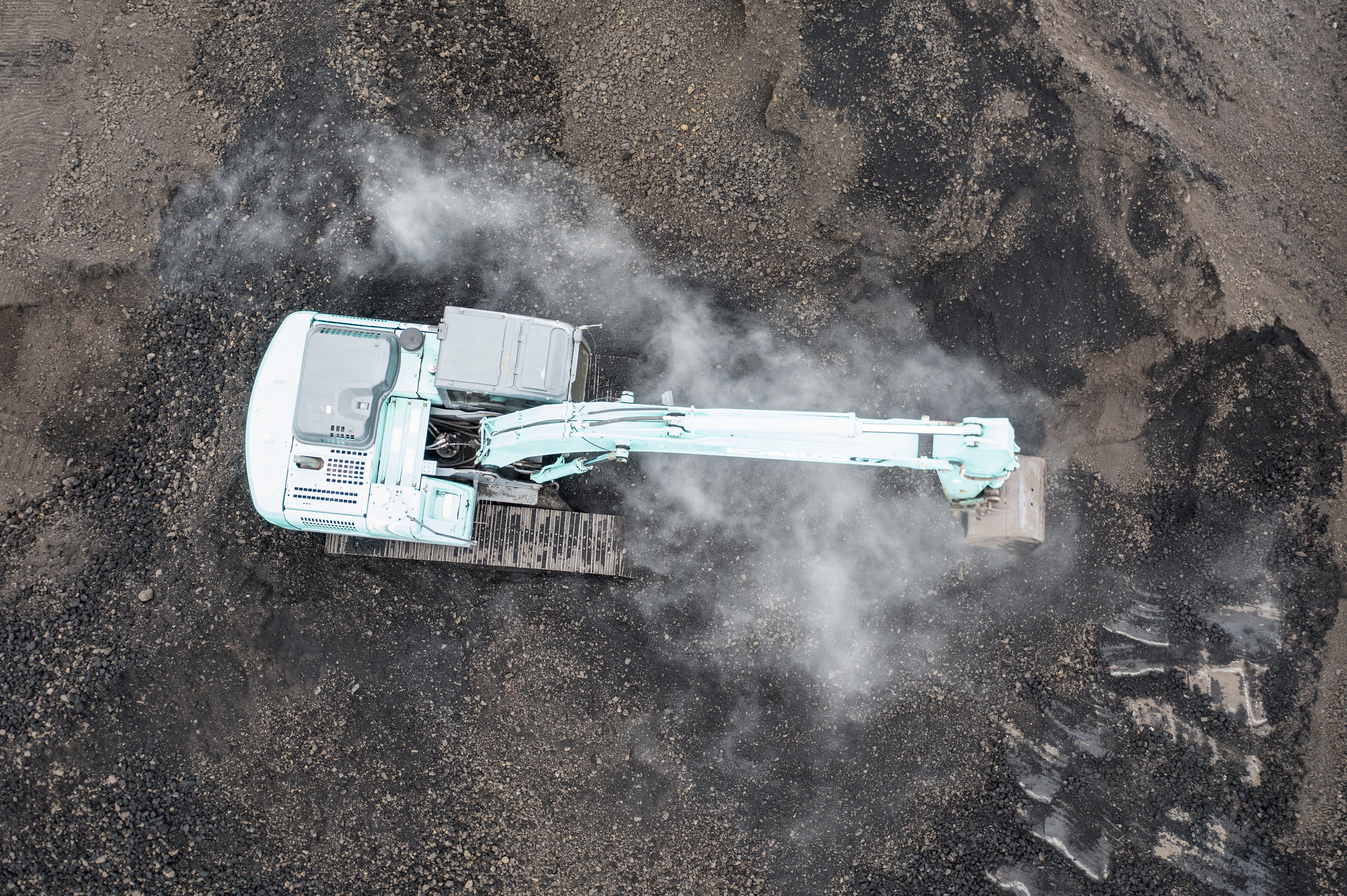 Alat berat dioperasikan untuk proses bongkar-muat batu bara