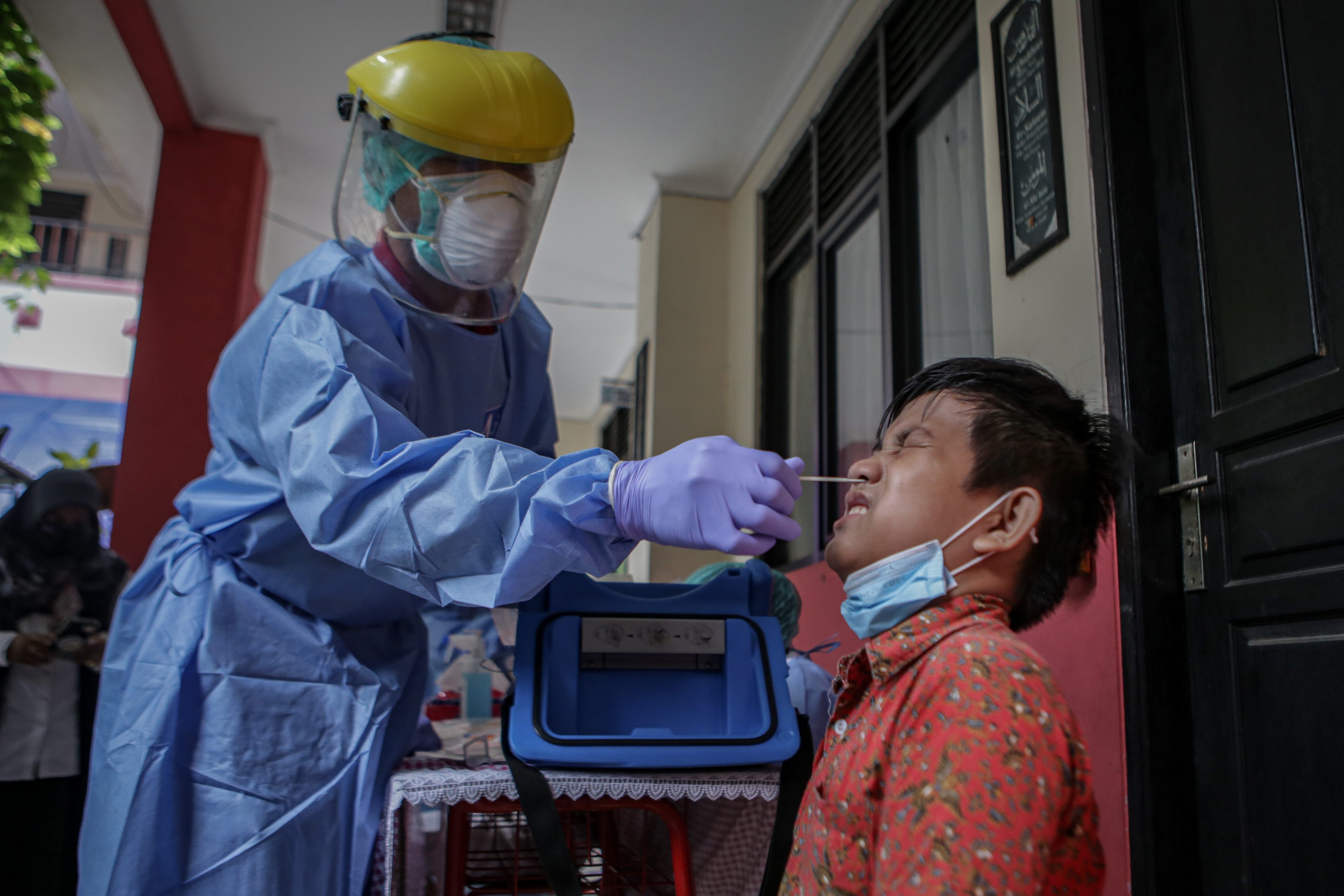 Petugas kesehatan melakukan tes usap PCR kepada siswa SDN Gebang Raya 2, Kota Tangerang, Banten, Rabu (12/1/2022)