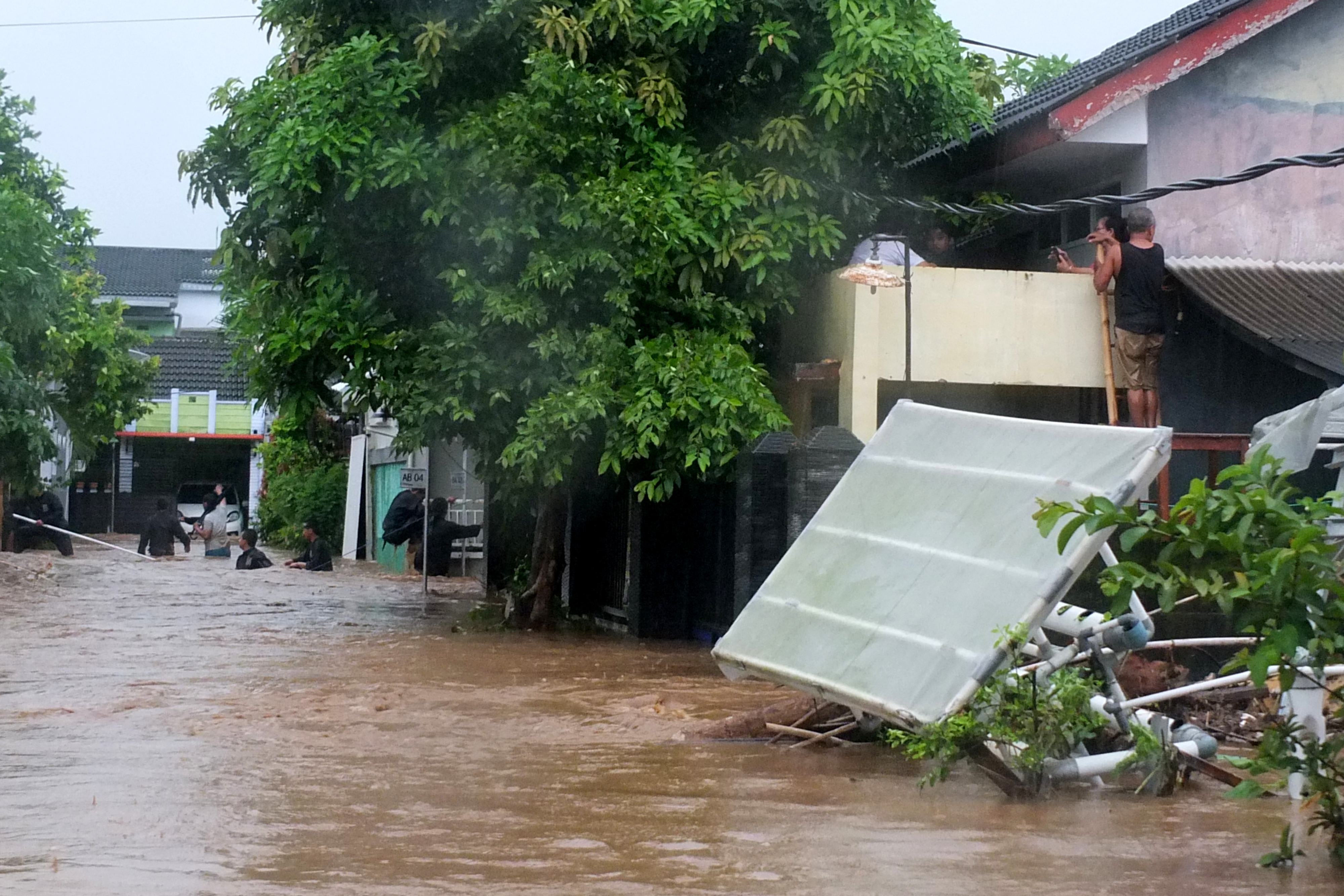 Warga berada di rumahnya ketika terjadi banjir di Perumahan Bumi Mangli, Kaliwates, Jember, Jawa Timur, Minggu (9/1/2022).