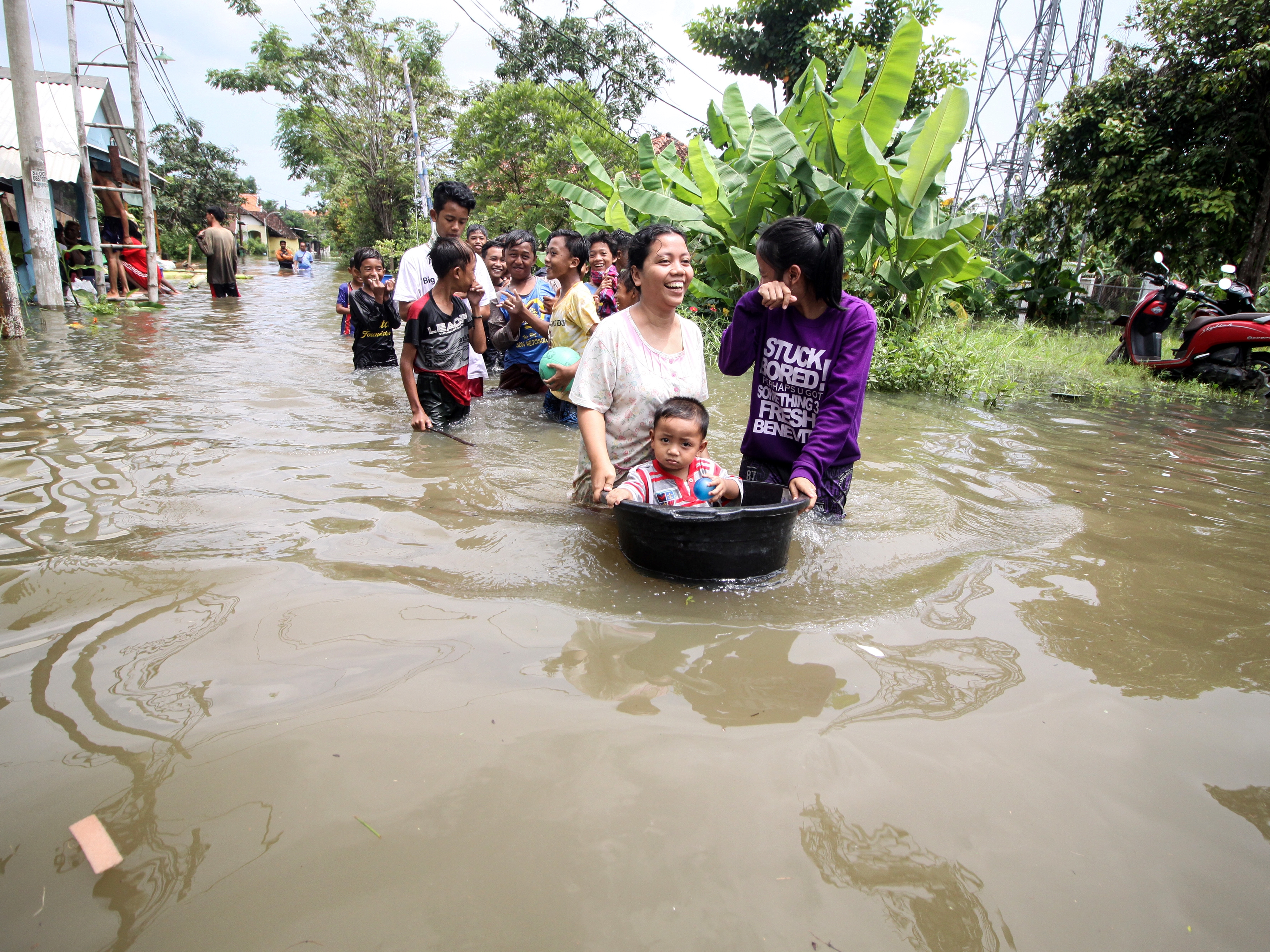 Warga melintasi banjir di Desa Rejoso, Kecamatan Rejoso, Pasuruan, Jawa Timur, Rabu (19/1/2022). 
