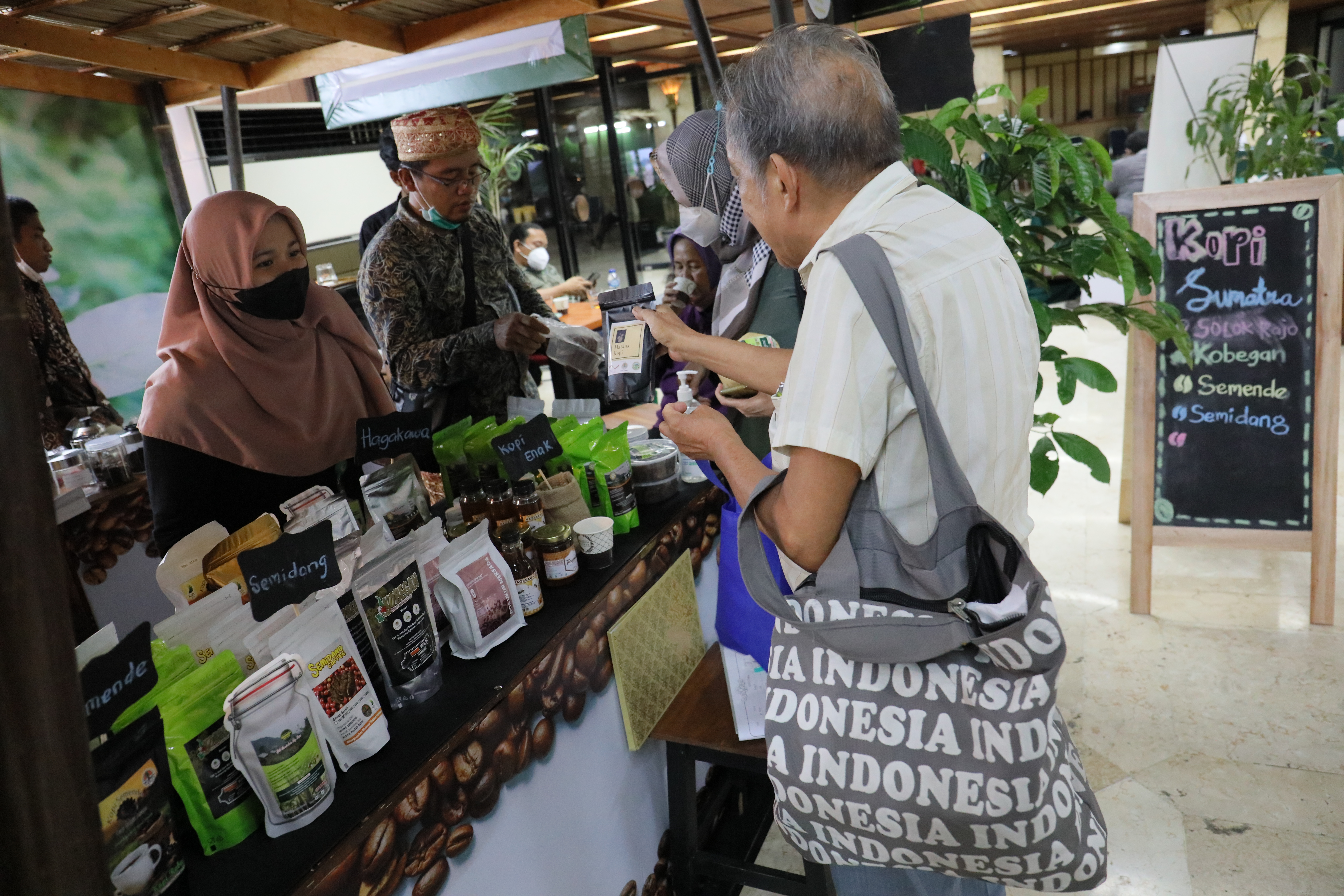 Pengunjung membeli produk kopi di salah satu tenant peserta Festival PeSoNa Kopi Agroforestry 2022 di Manggala Wanabakti, Jakarta.
