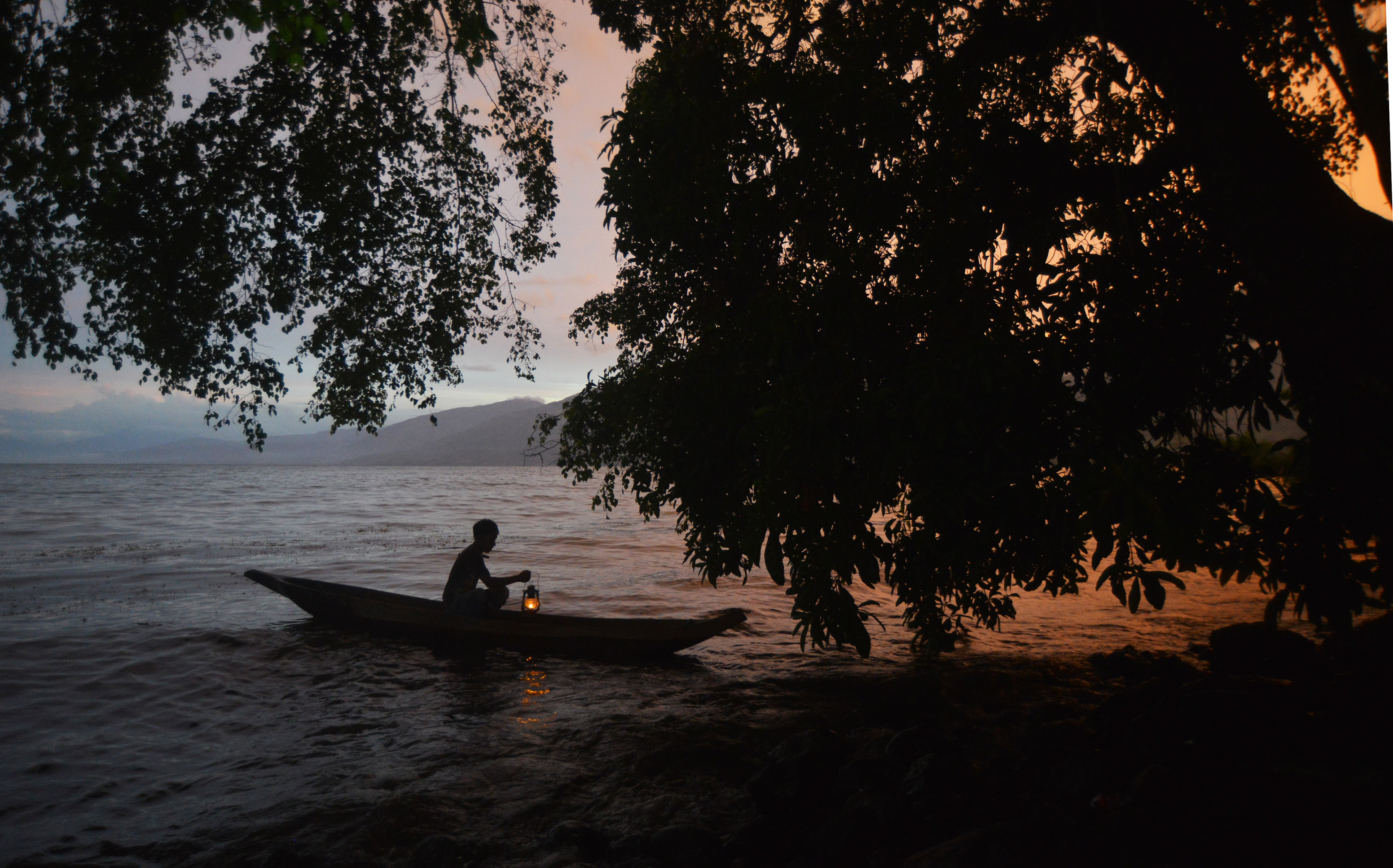  Seorang nelayan menyiapkan jala diterangi lentera, di Danau Singkarak, Nagari Sumpu, Kabupaten Tanah Datar, Sumatra Barat.