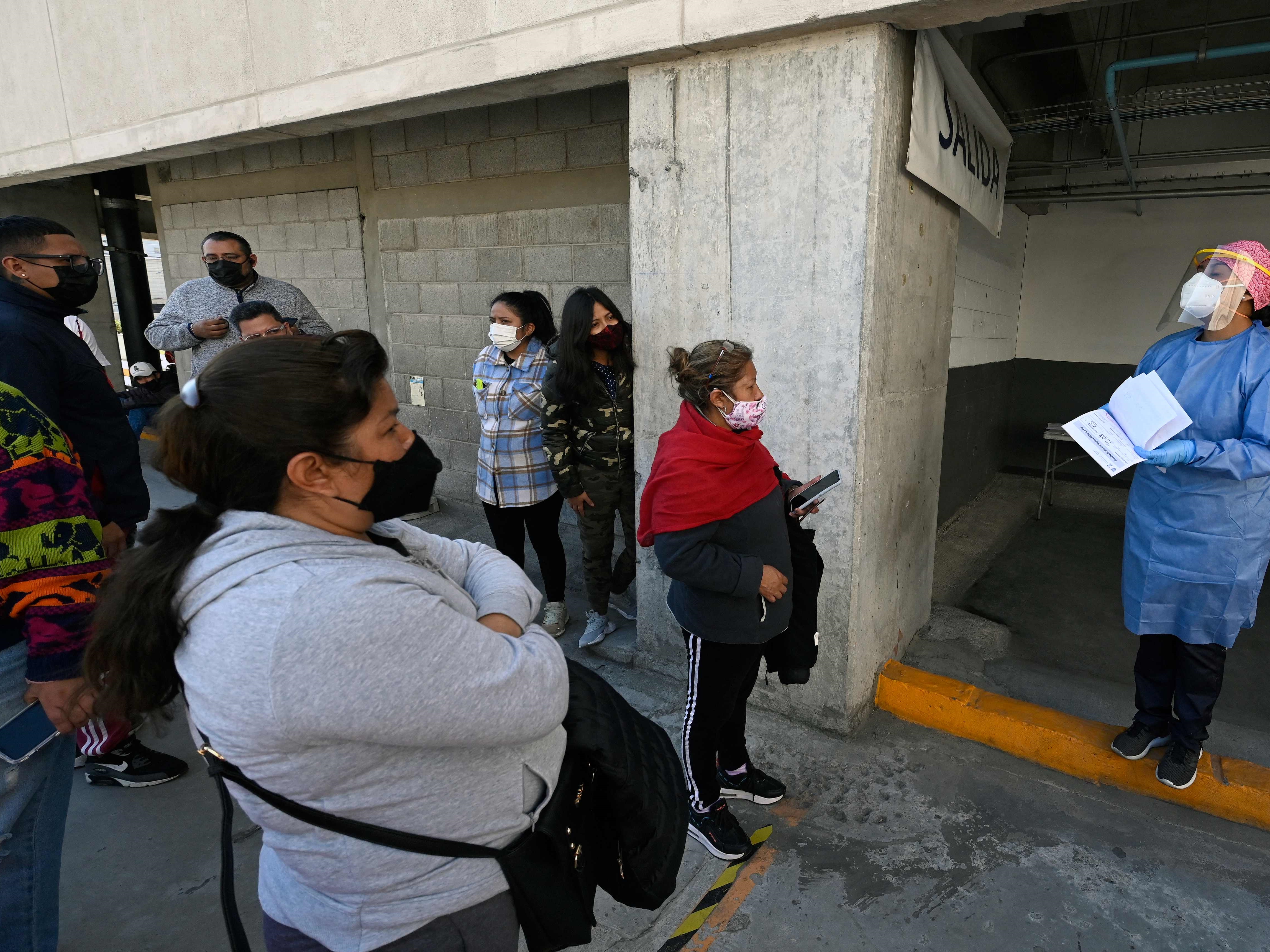 Petugas kesehatan memanggil orang untuk tes covid-19 di tempat parkir pusat perbelanjaan Via Vallejo, Mexico City, 5 Januari 2022.