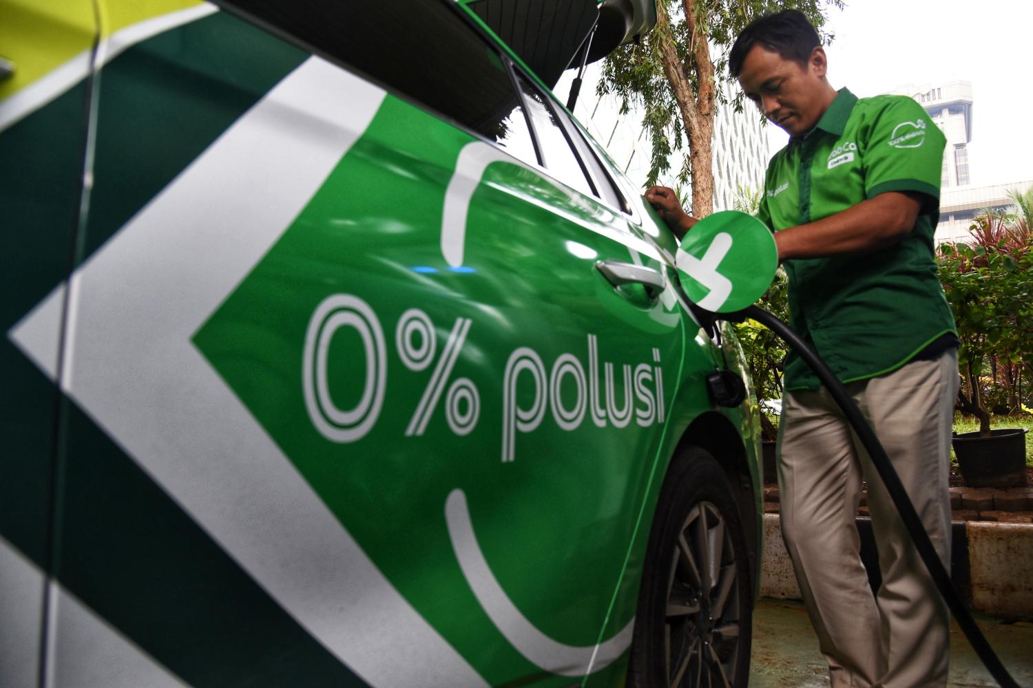  Pengemudi Grab Electric mengisi daya listrik kendaraan di Stasiun Pengisian Kendaraan Listrik Umum (SPKLU), Jakarta Pusat.