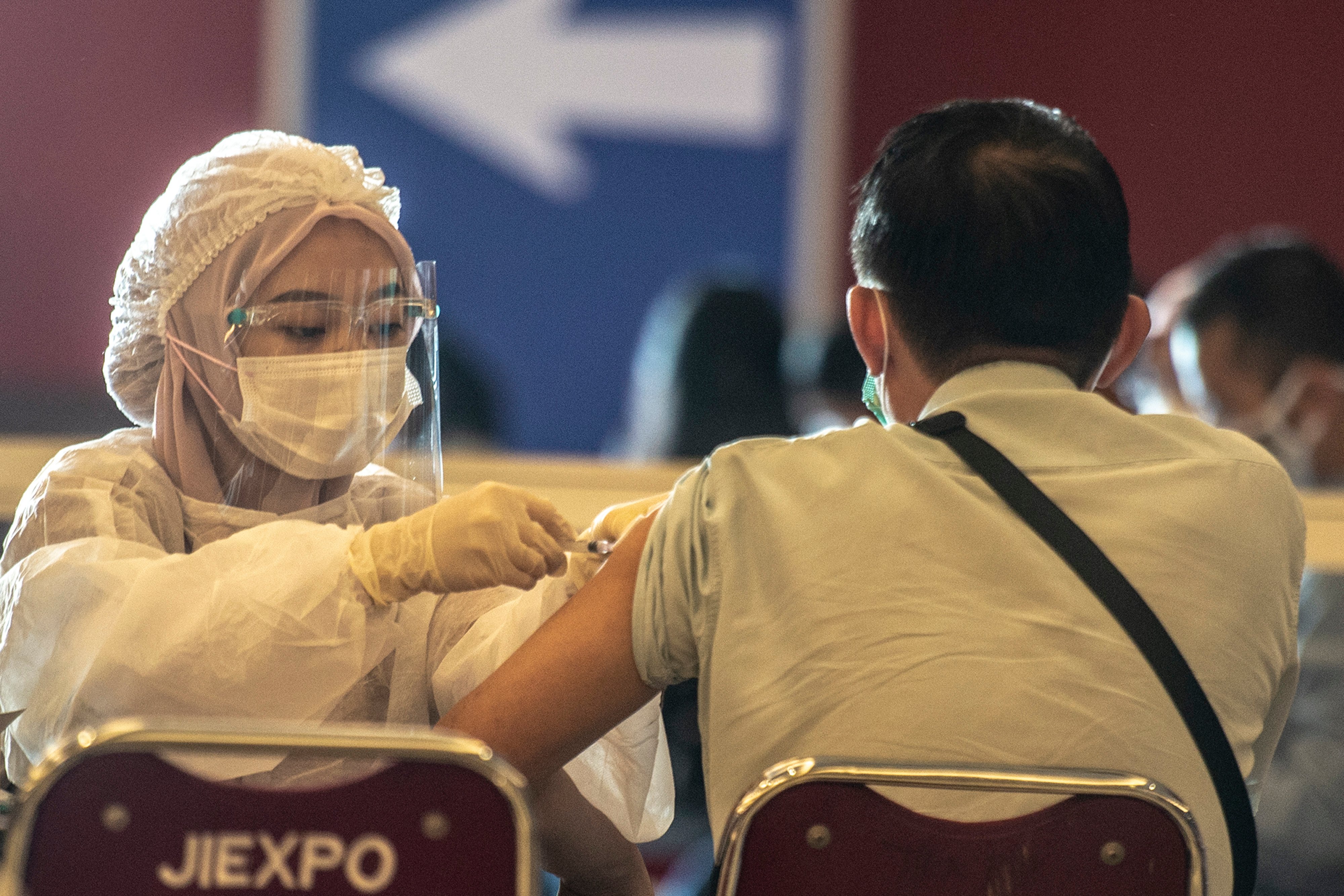  Petugas kesehatan menyuntikkan vaksin dosis ketiga atau booster COVID-19 kepada warga di Jiexpo Kemayoran