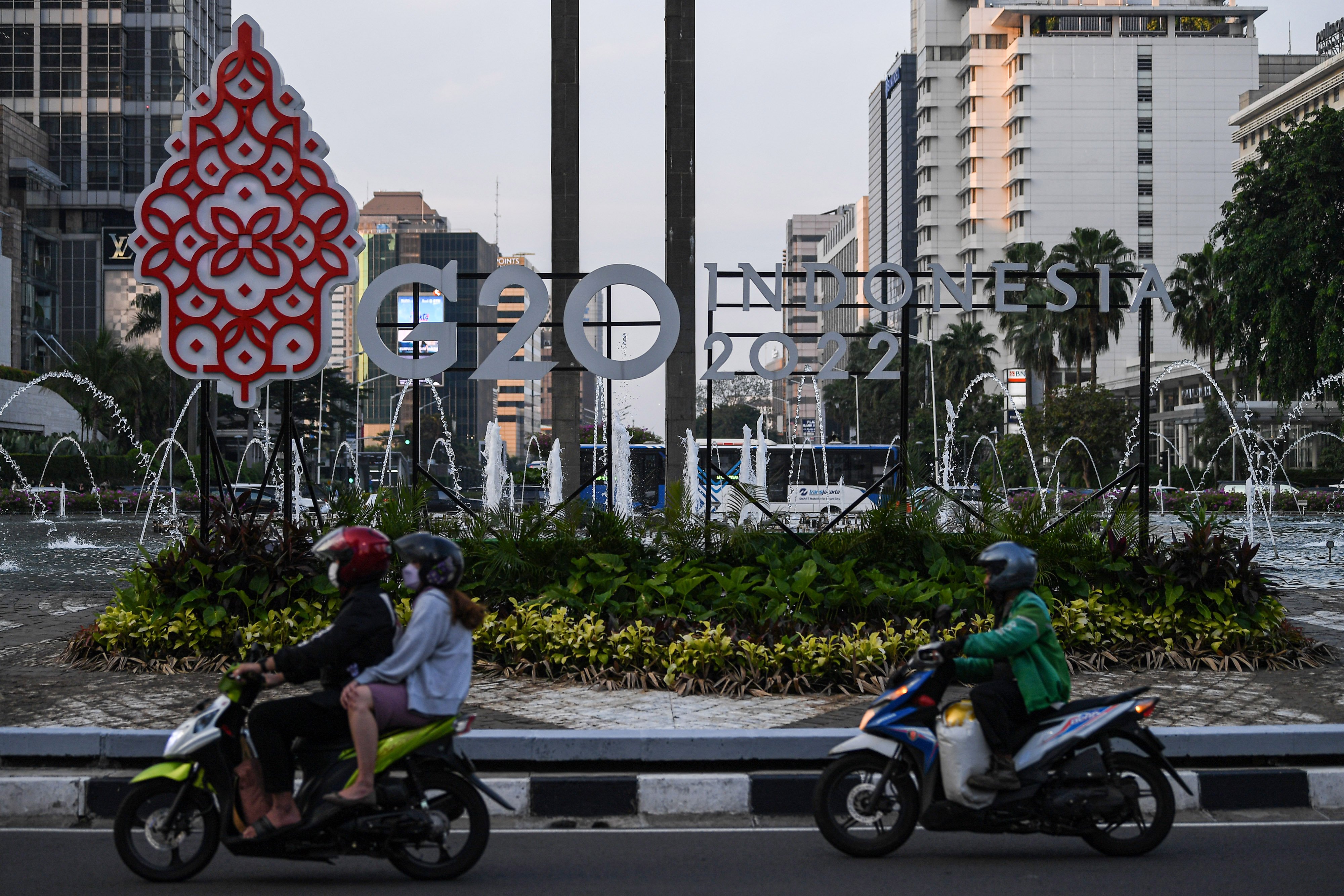 Pengendara motor melintas di depan logo Presidensi G20 Indonesia 2022 di Bundaran HI, Jakarta, Jumat (21/1/2022). 