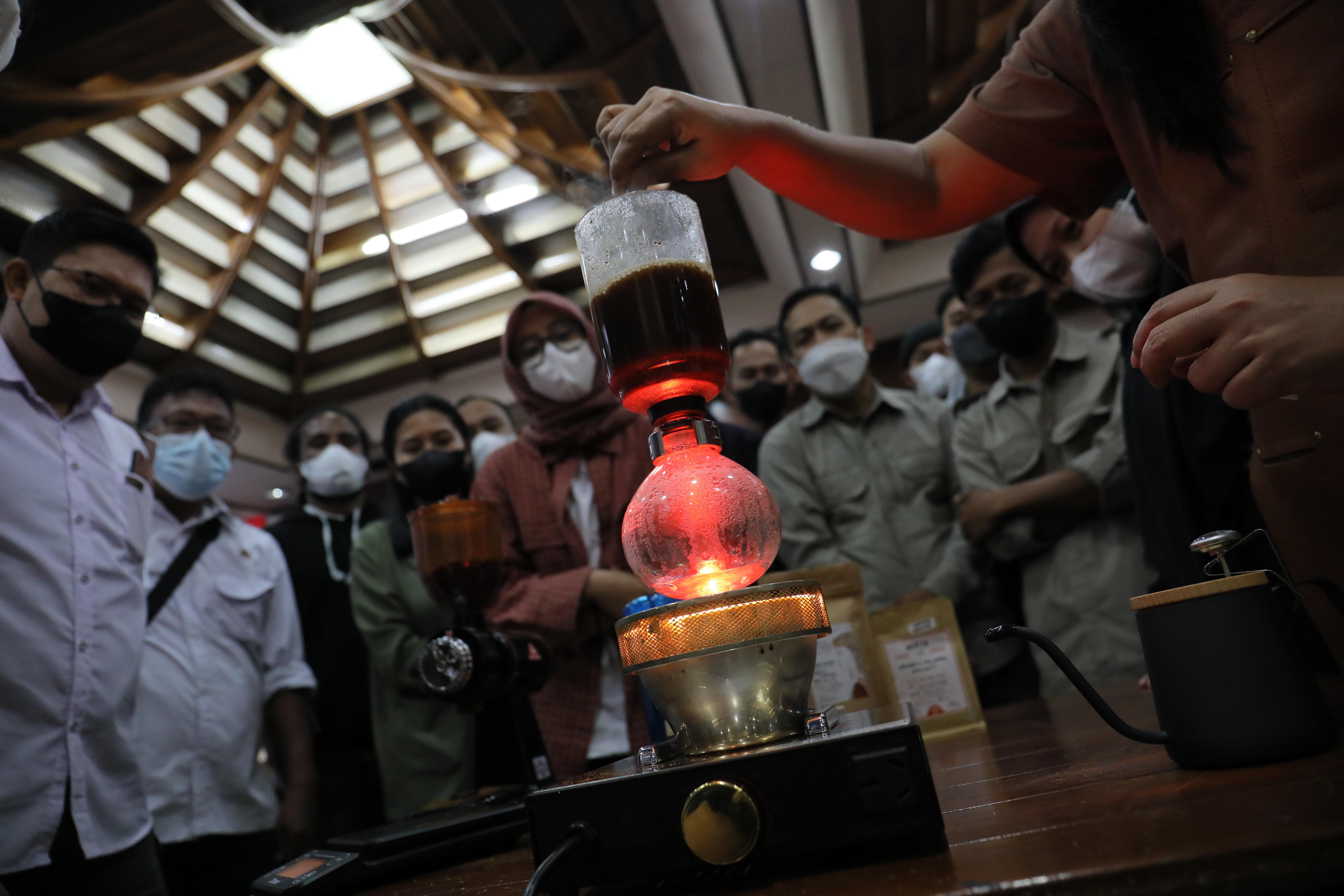Pengunjung Festival Kopi memperhatikan teknik menyeduh kopi manual dengan menggunakan sifon.