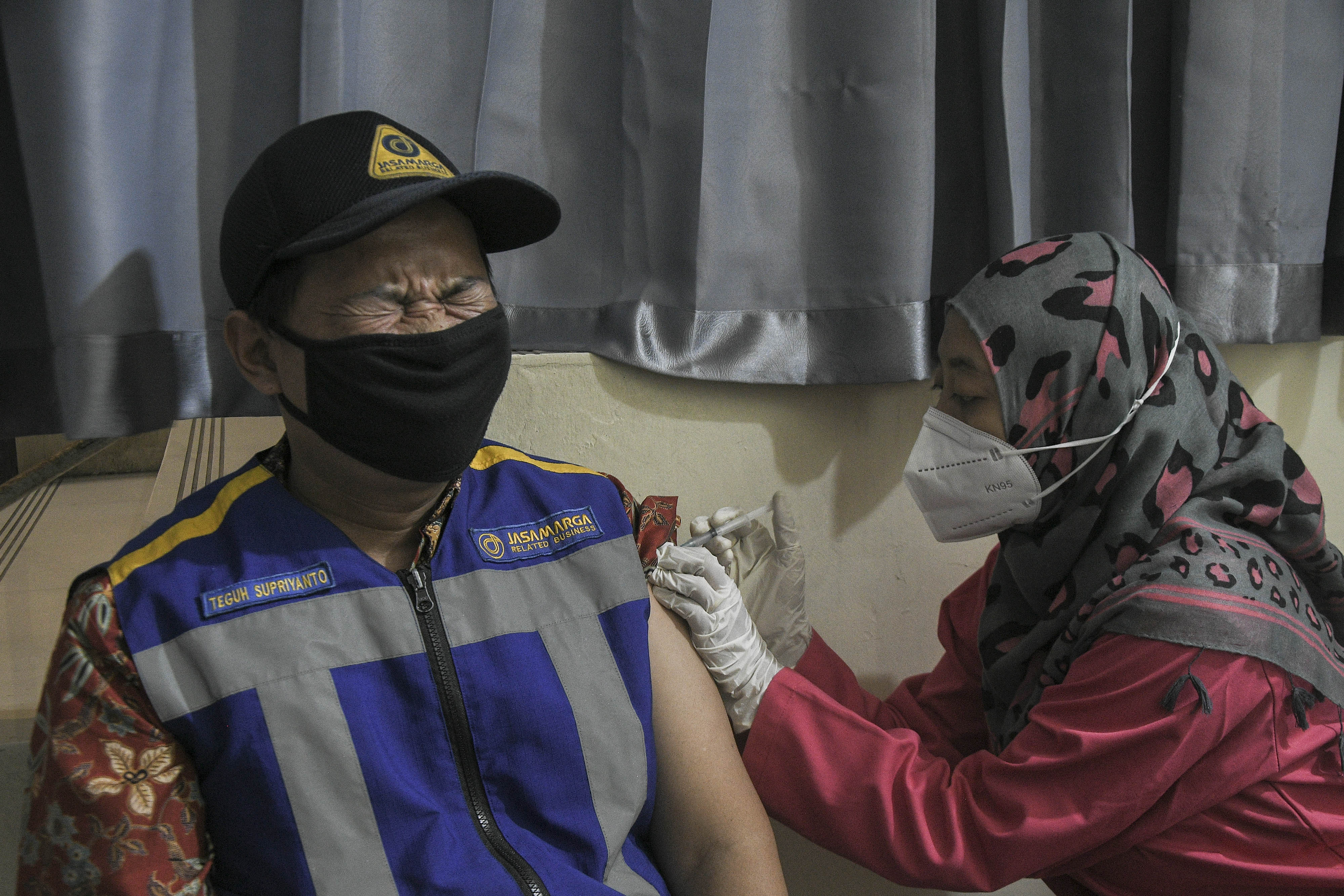 Nakes menyuntikkan vaksin covid-19 dosis booster kepada petugas Jasa Marga di rest area km 19, Tambun, Kabupaten Bekasi, Jawa Barat.