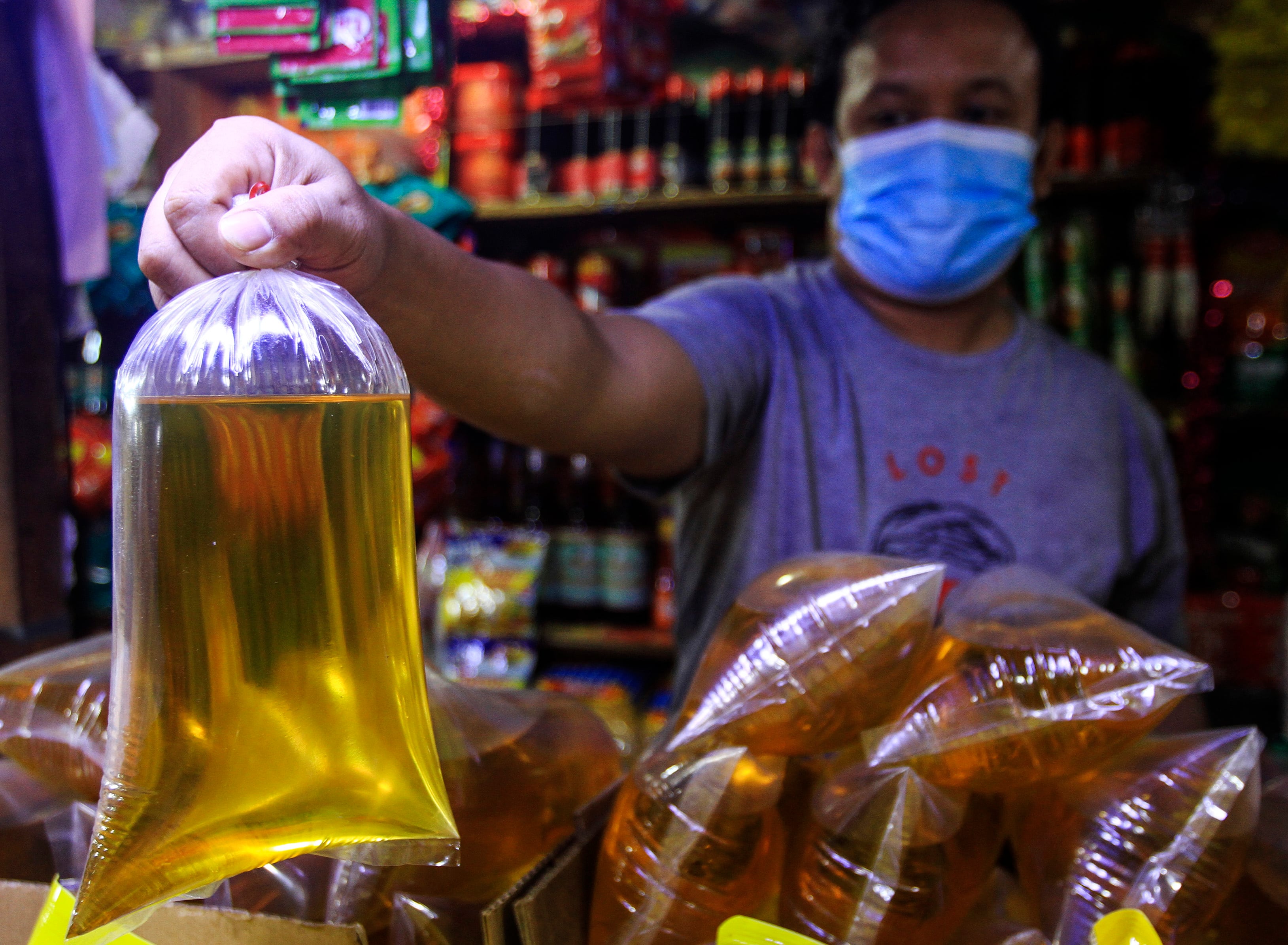 Pedagang menunjukkan minyak goreng curah
