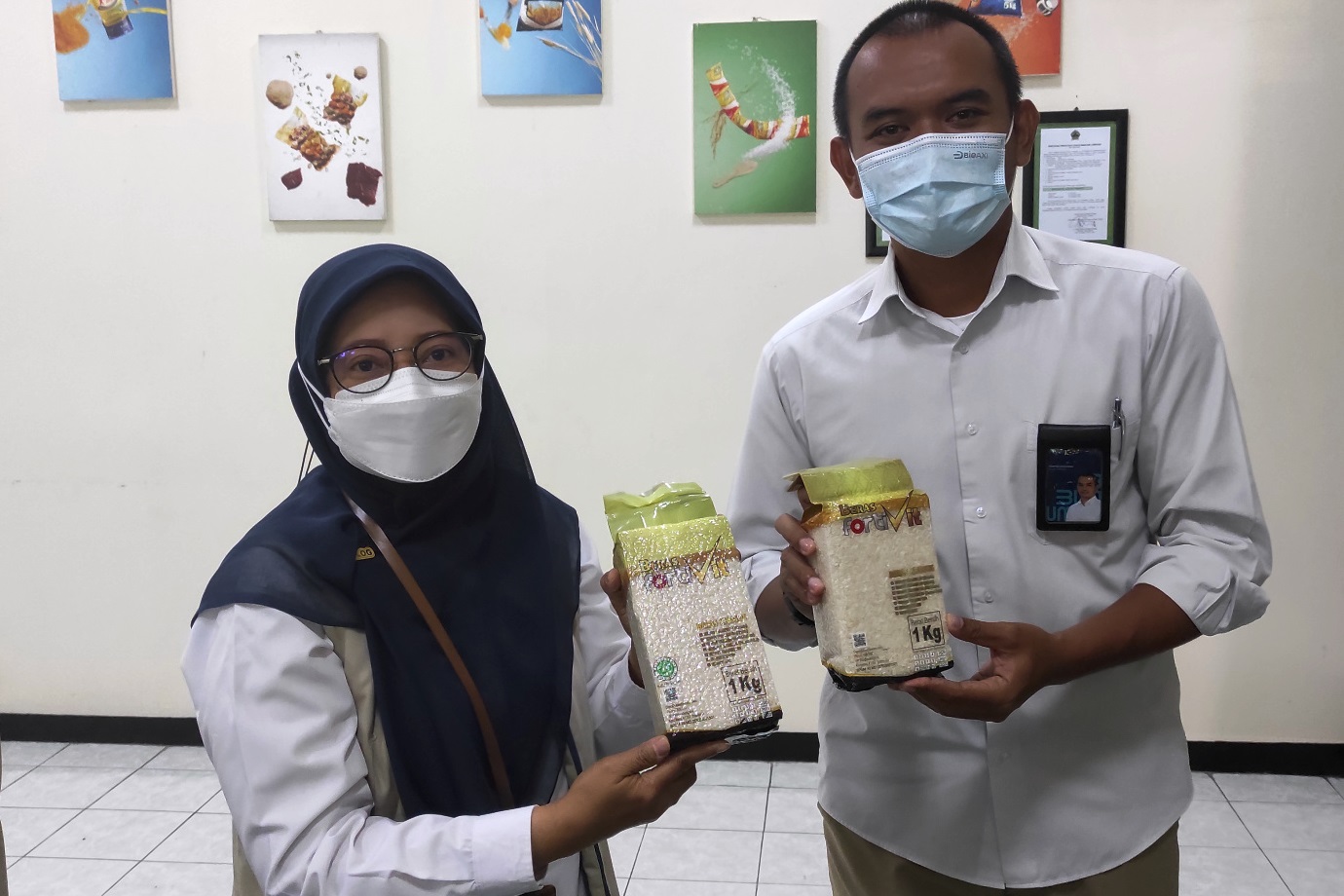 Kepala Bulog Surakarta, Sri Muniati dengan stafnya, Taufiqurrahman memperlihat beras Fortivit, yang menyehatkan dan mencegah stunting. 