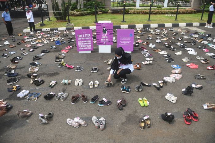 Pegiat perempuan merapikan sepatu saat aksi diam 500 Langkah Awal Sahkan RUU TPKS di depan gedung DPR, Jakarta, Rabu (25/11/2020).