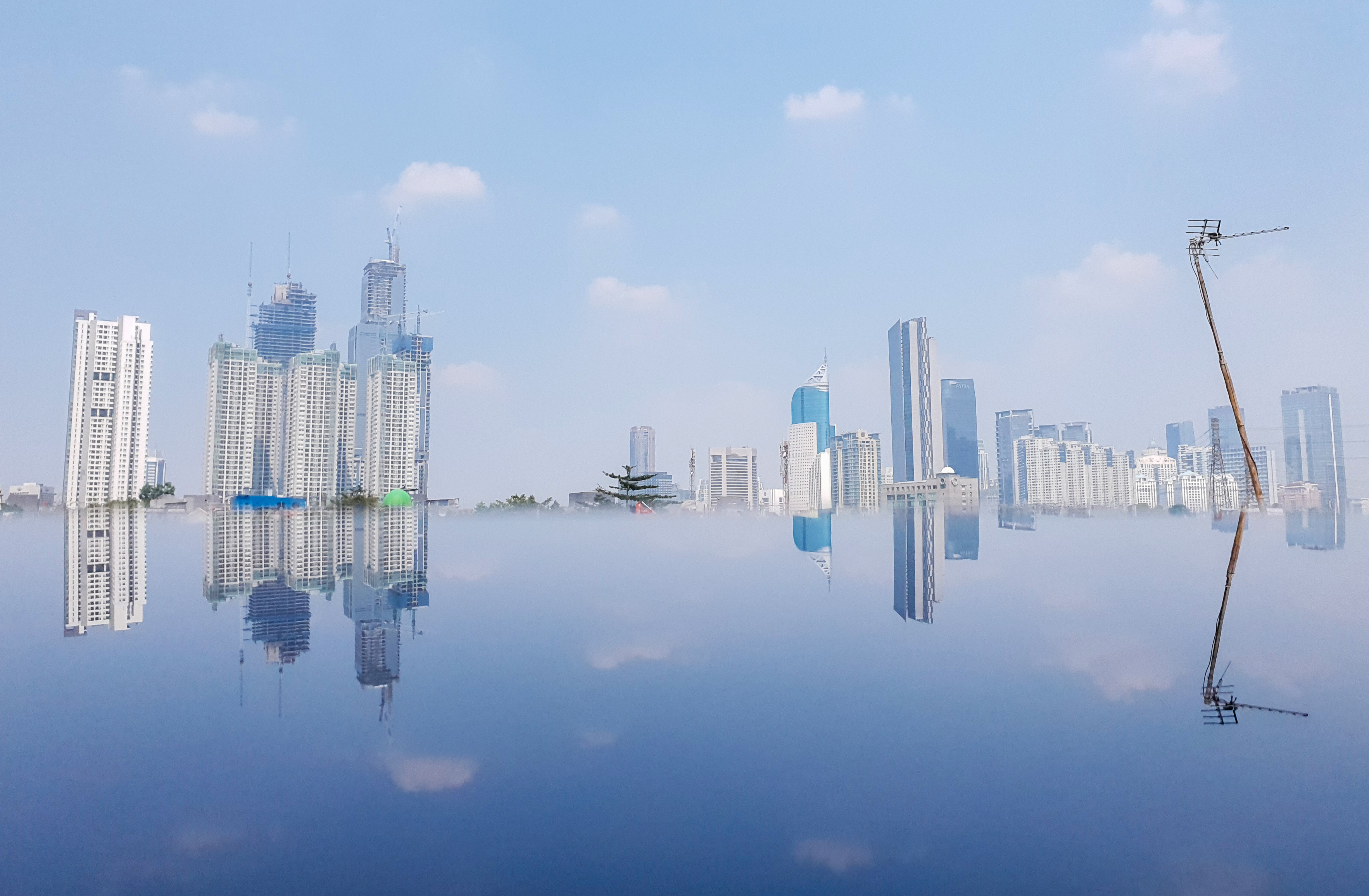 Refleksi gedung bertingkat di Jakarta, Kamis (26/8/2021). Kemenkeu memprediksi defisit anggaran 2022 akan turun ke 3,3% PDB.