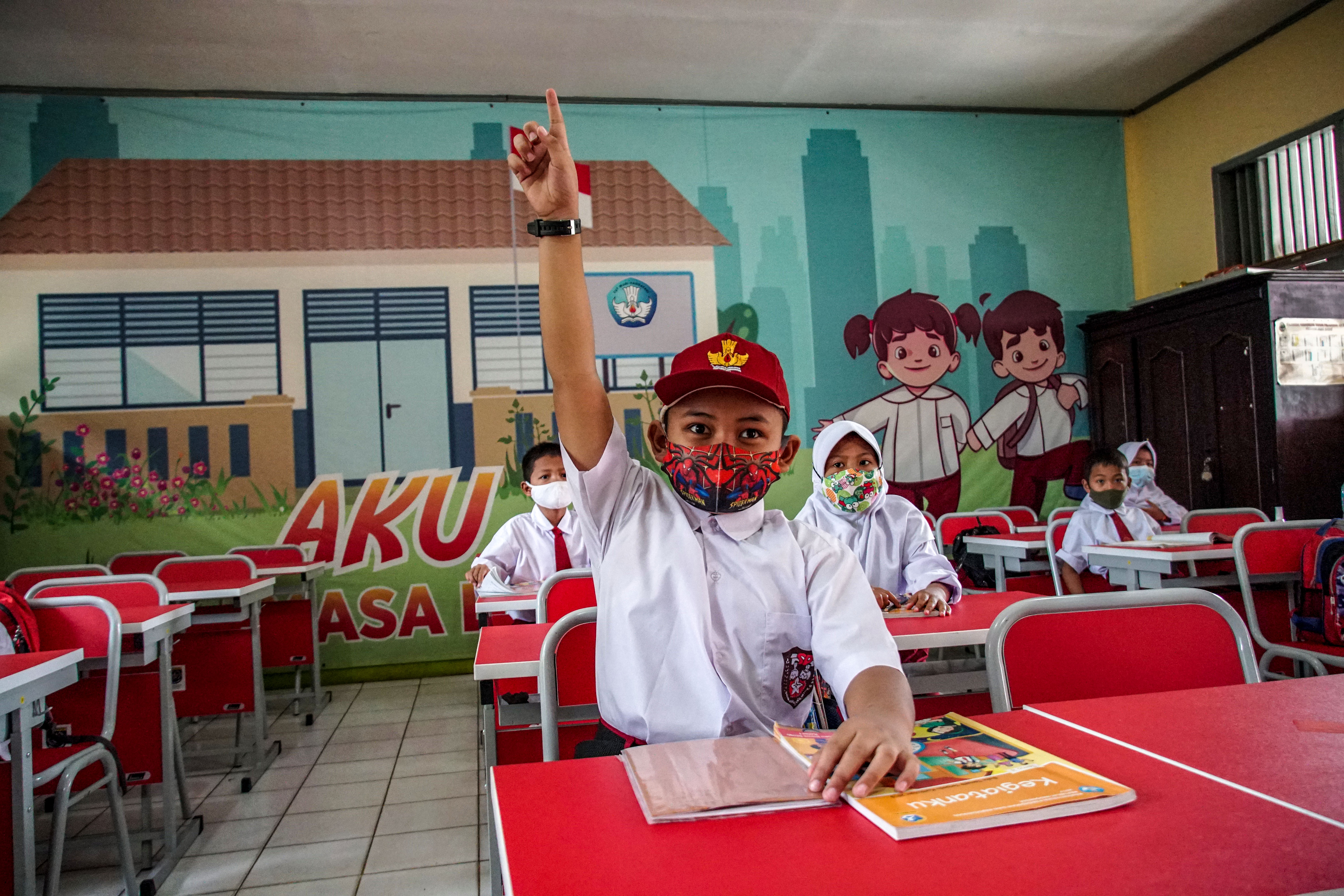 Siswa mengangkat tangan saat diabsen guru kala pembelajaran tatap muka terbatas di SDN Depok Baru 8, Kota Depok, Jawa Barat.