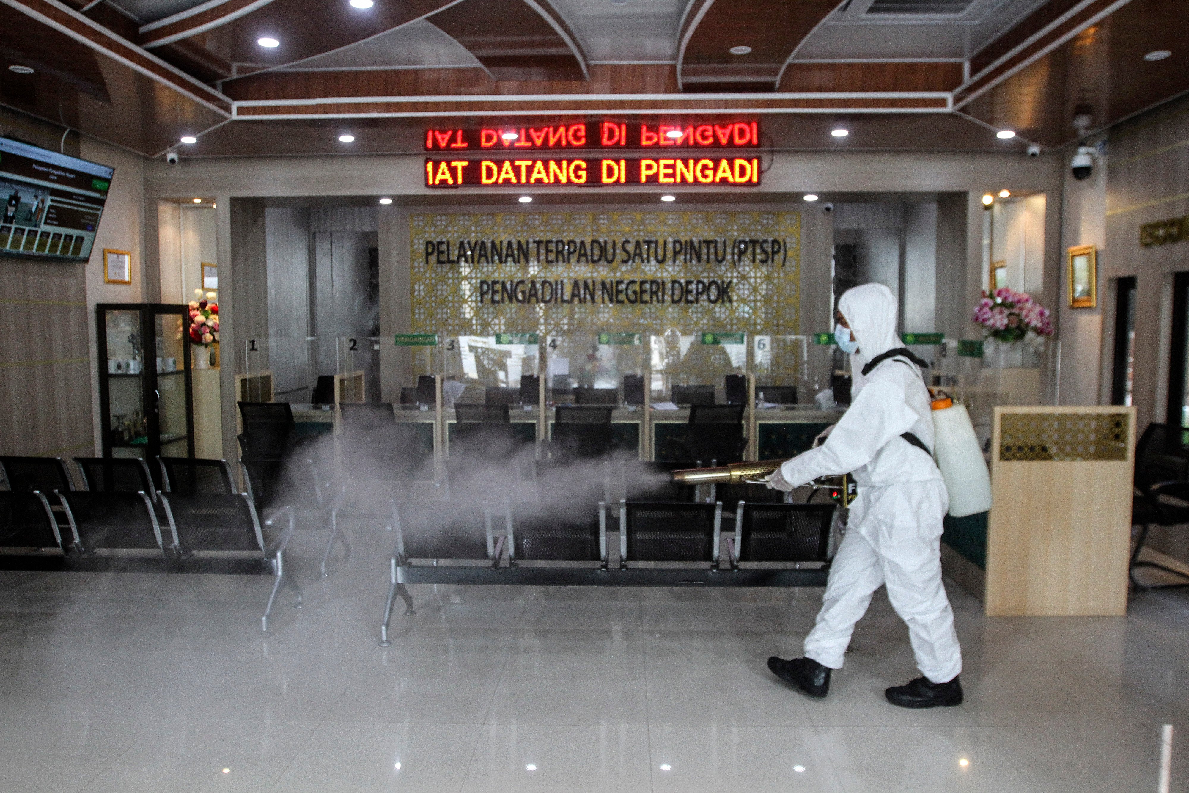 Petugas Damkar menyemprotkan cairan disinfektan di ruang pelayanan Pengadilan Negeri Depok, Jawa Barat, Selasa (25/1/2022). 