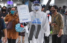  Anggota komunitas pecinta Transjakarta mengenakan baju hazmat melakukan sosialisasi protokol kesehatan di Halte Transjakarta Harmoni.