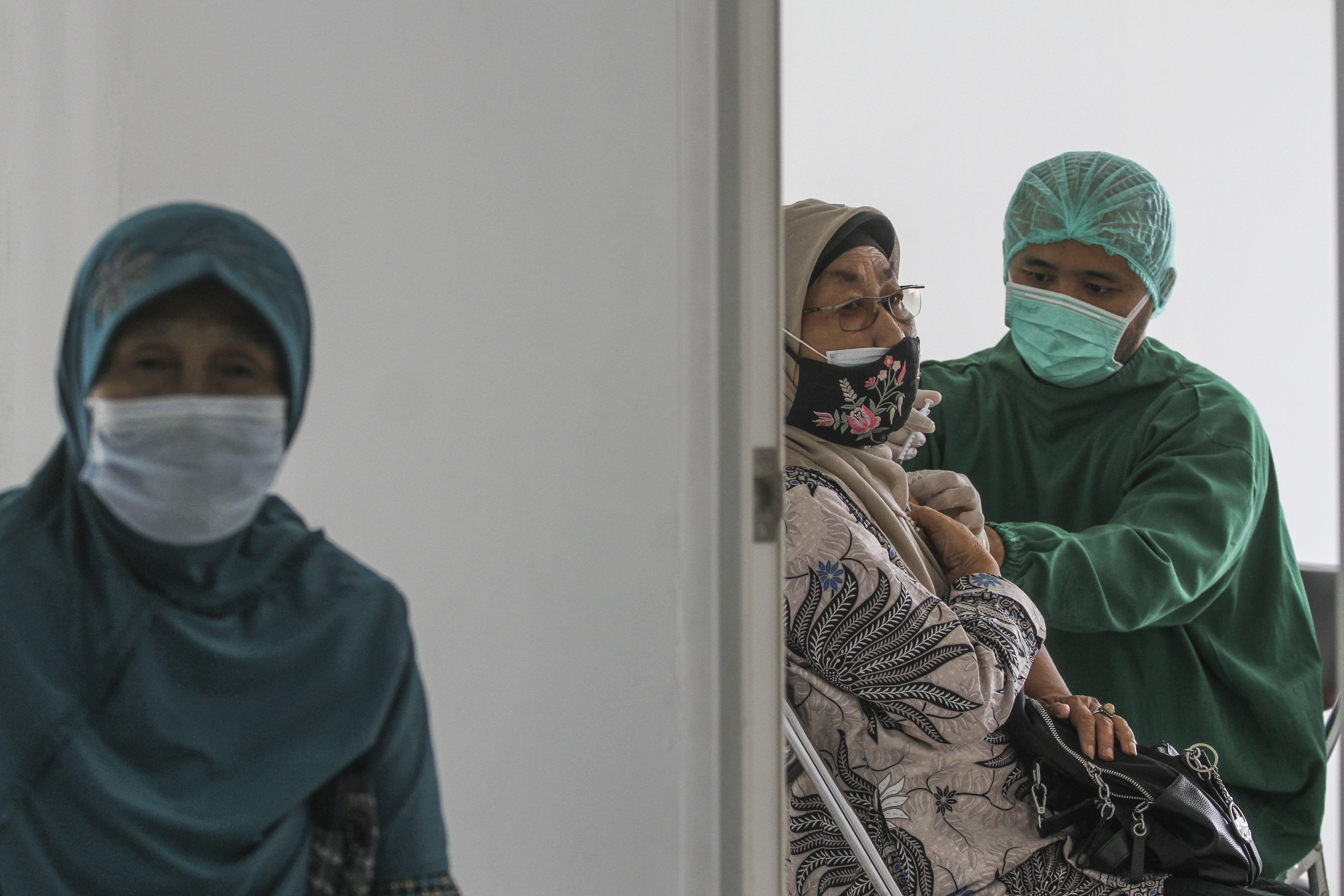 VAKSINASI BOOSTER UNTUK LANSIA: Petugas menyuntikan vaksin lanjutan (booster) untuk lansia di Sentra Vaksinasi RSUI, Depok, Jabar.