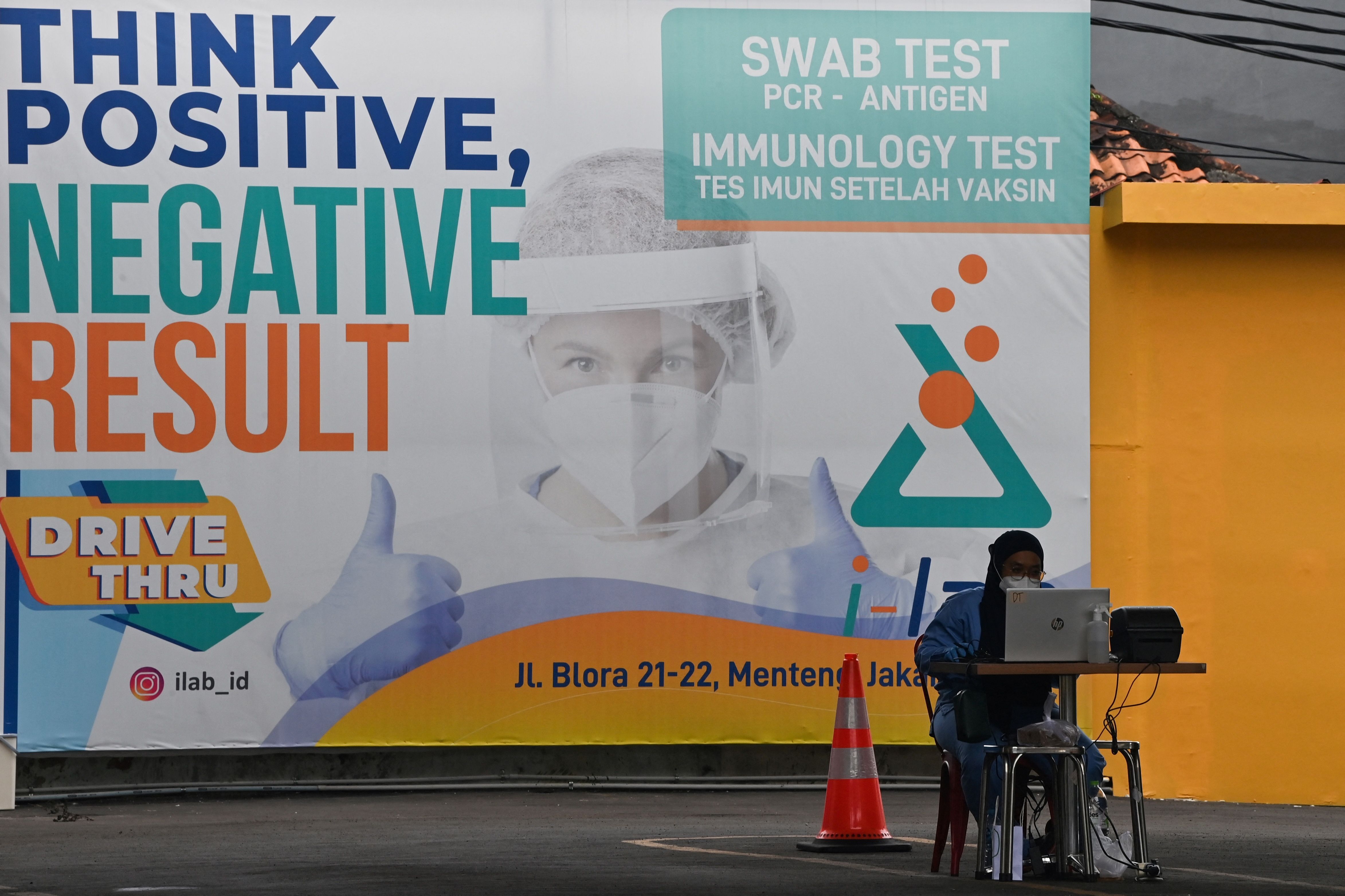 Seorang pekerja berada di depan sebuah fasilitas pengujian covid-19 di Jakarta.