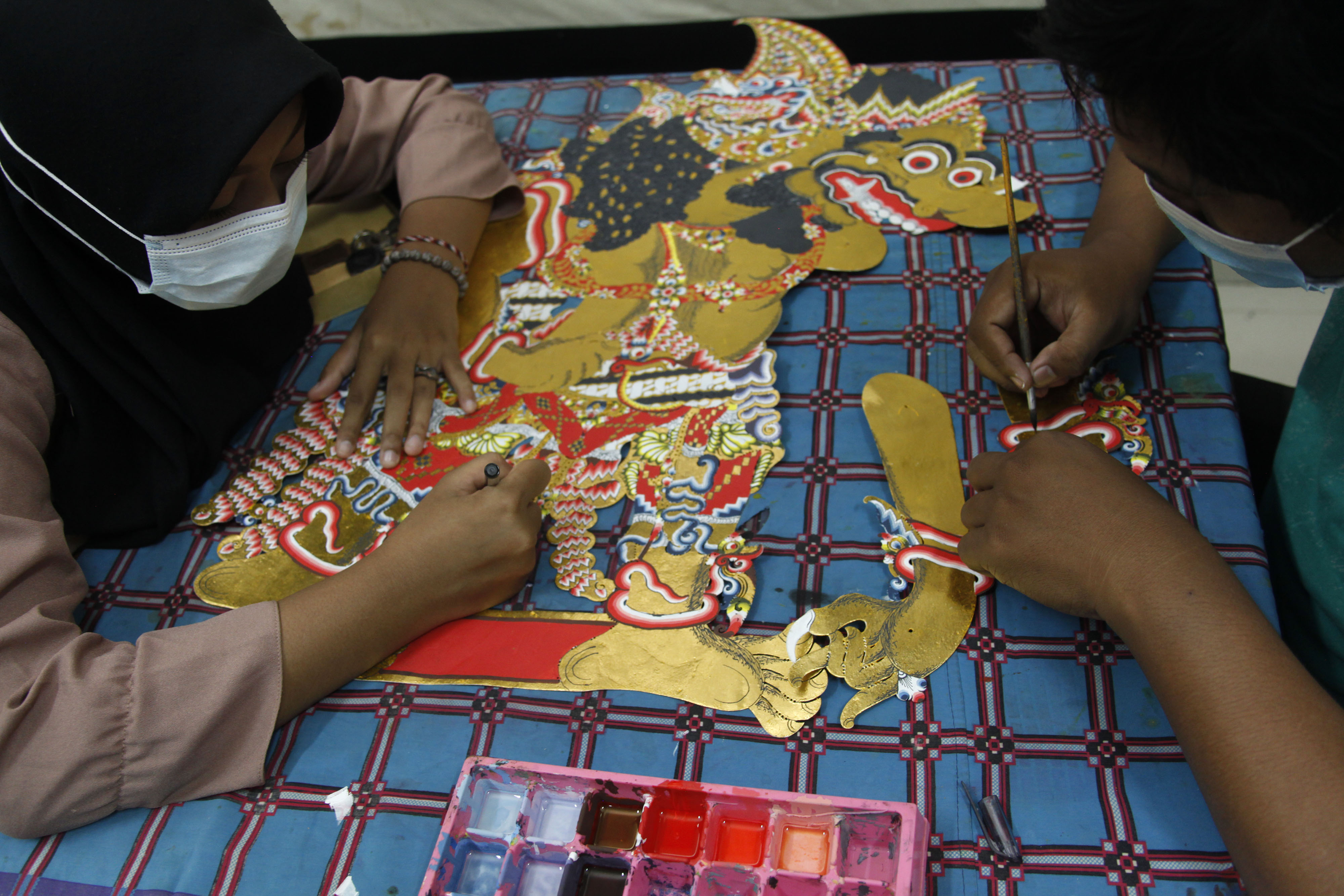 Pengrajin sedang membuat wayang kuilit