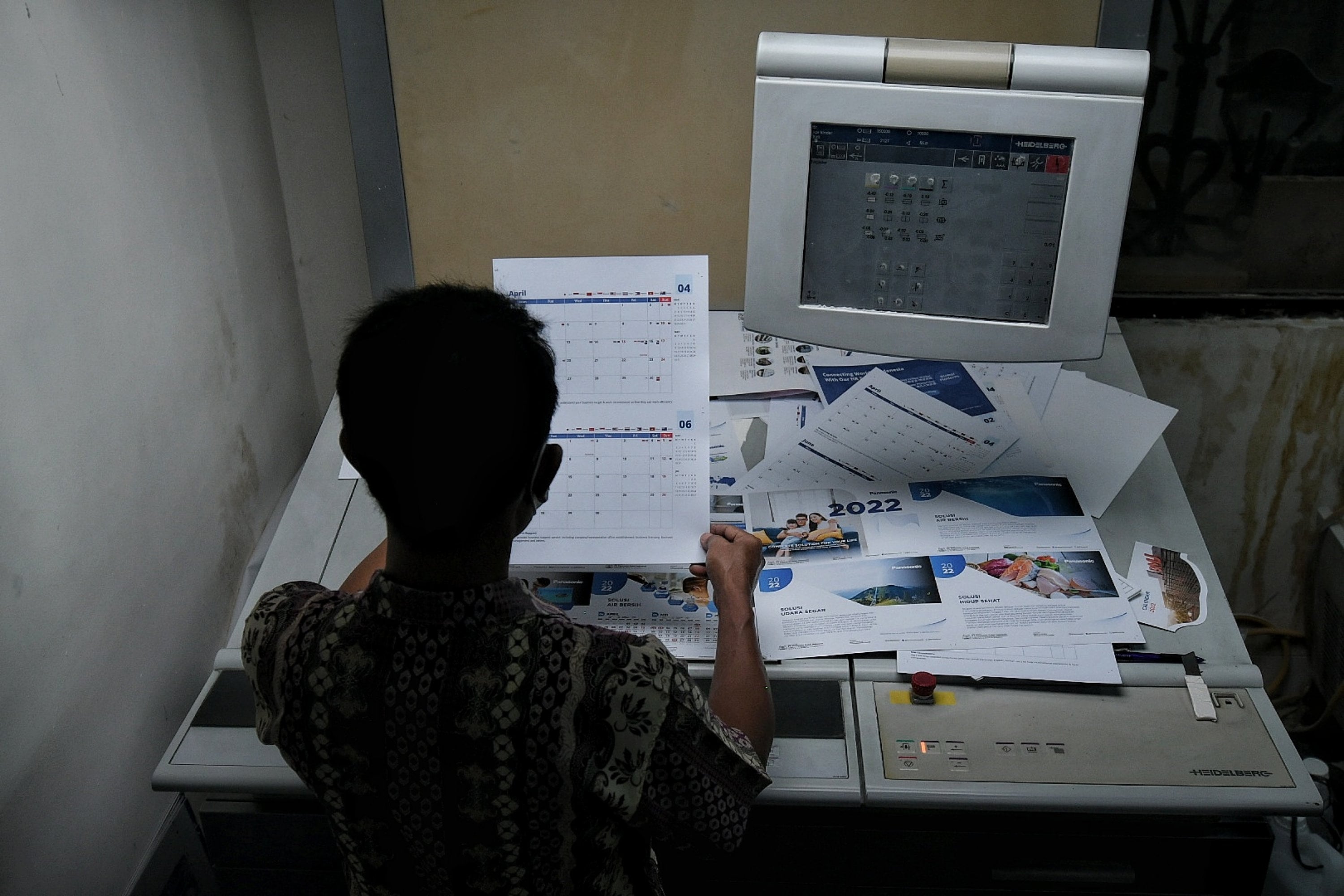 Pekerja saat memeriksa kualitas cetakan kalender tahun 2022 di kawasan Bendungan Hilir, Jakarta, Jumat (3/12/2021).