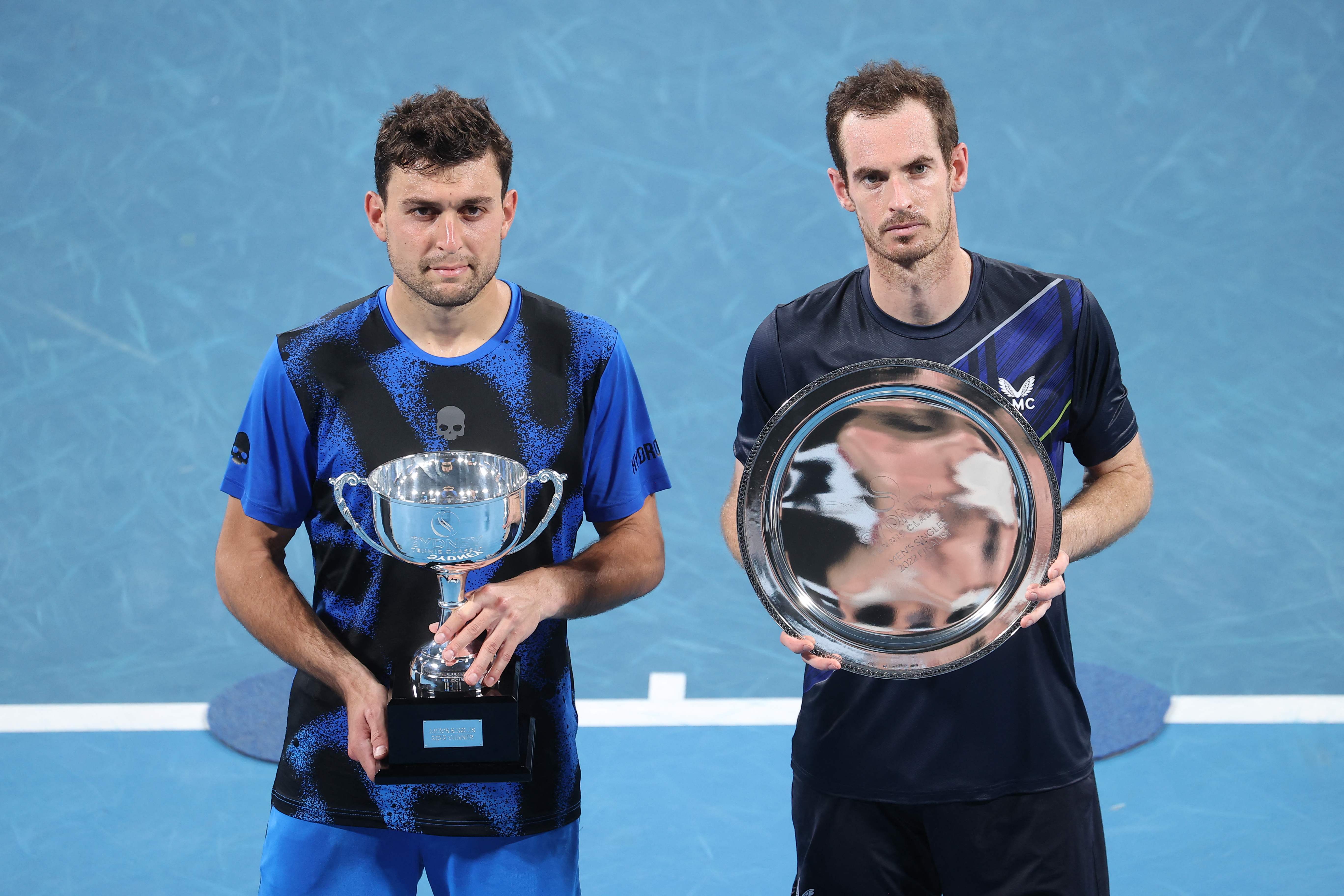 Aslan Karatsev memegang trofi juara ATP SYdney seusai mengalahkan Andy Murray di final