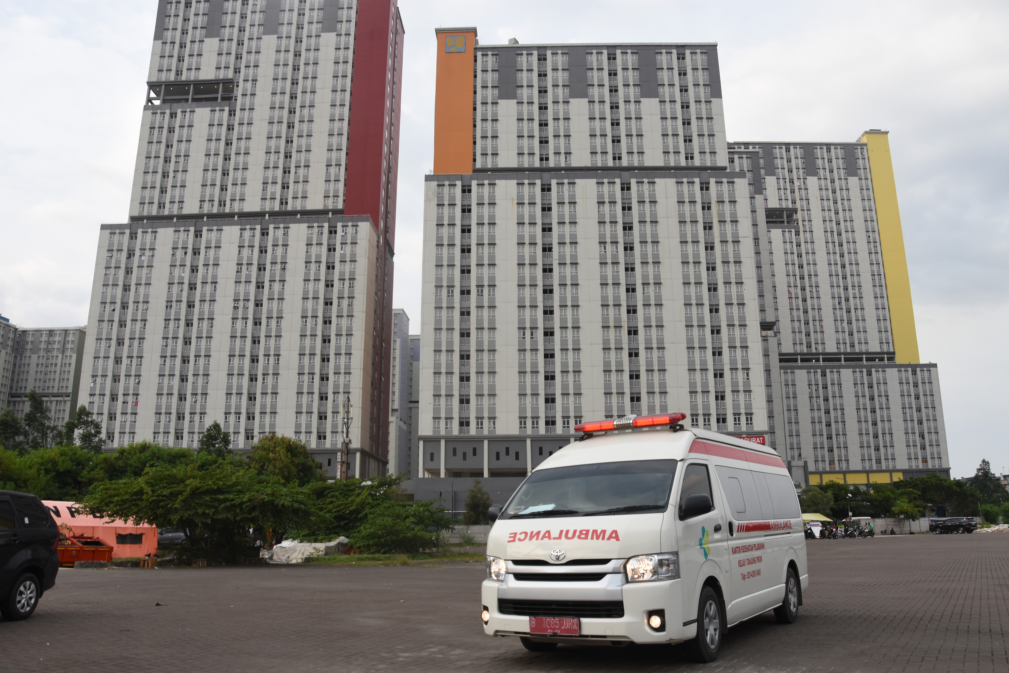  Mobil ambulans berjalan keluar usai mengantarkan pasien Covid-19 di RSDC Wisma Atlet Kemayoran, Jakarta.