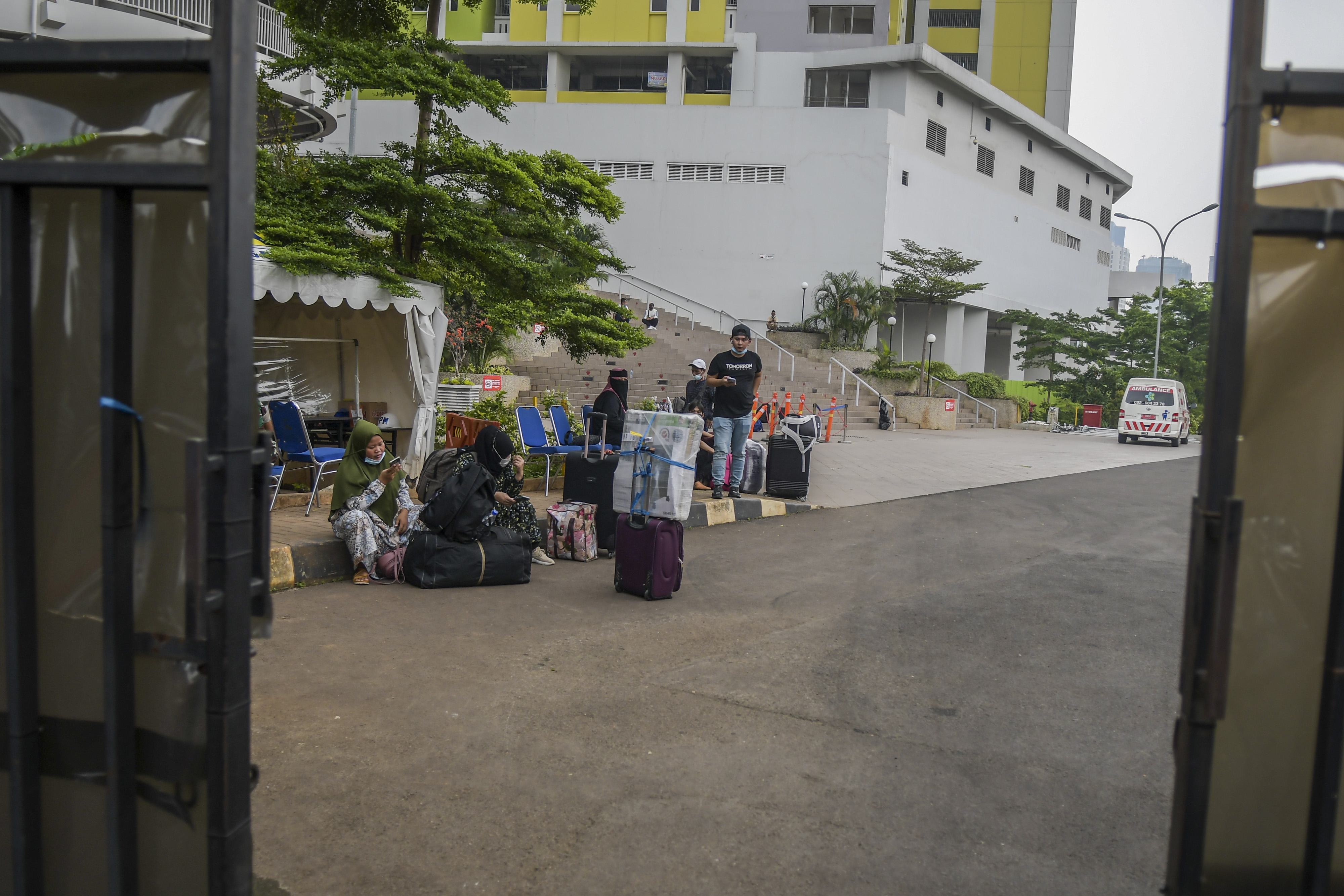 MASA KARANTINA: Pekerja Migran Indonesia  menunggu kendaraan usai menjalani karantina di kompleks Rusun Pasar Rumput, Jakarta.