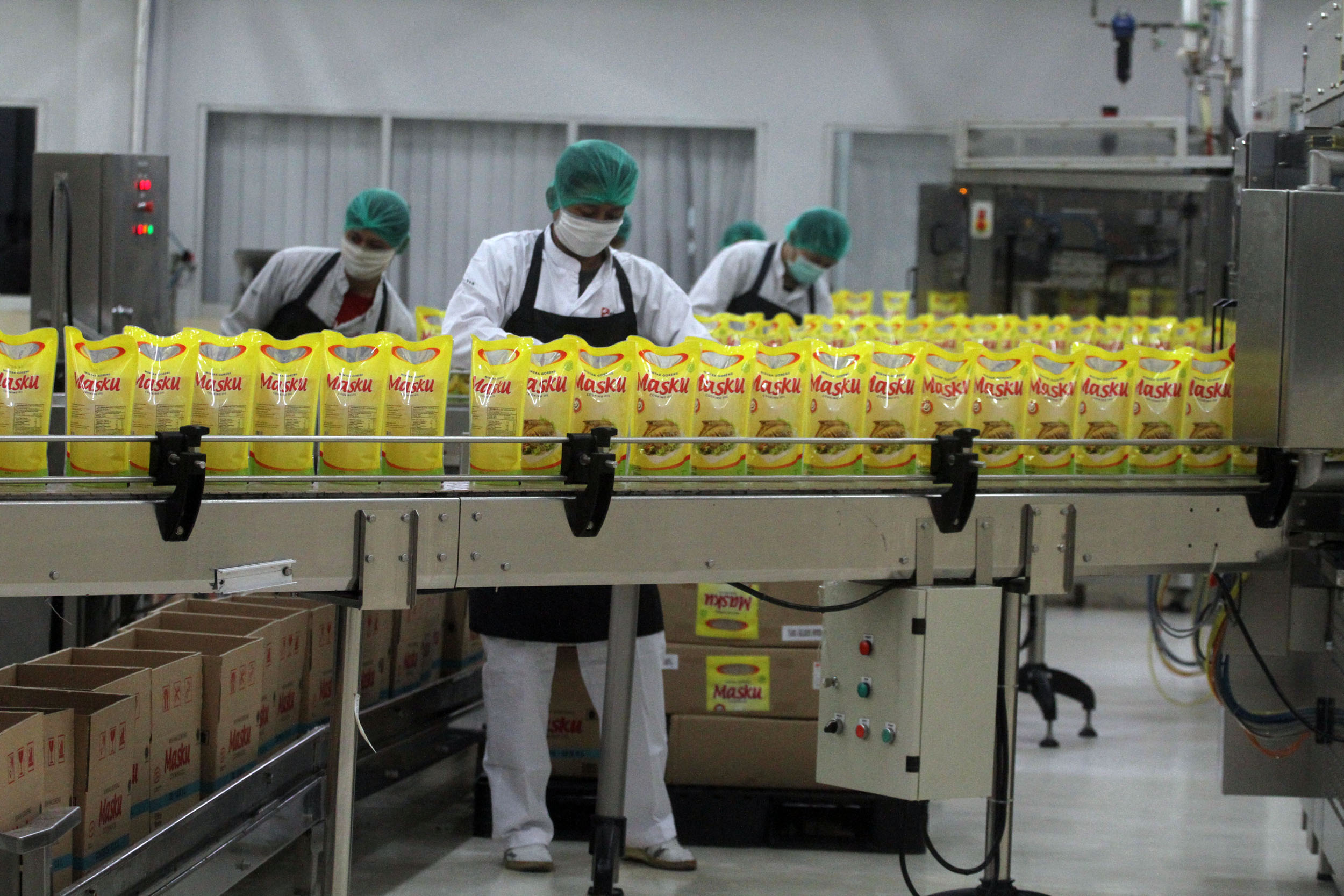 Pekerja mengemas minyak goreng