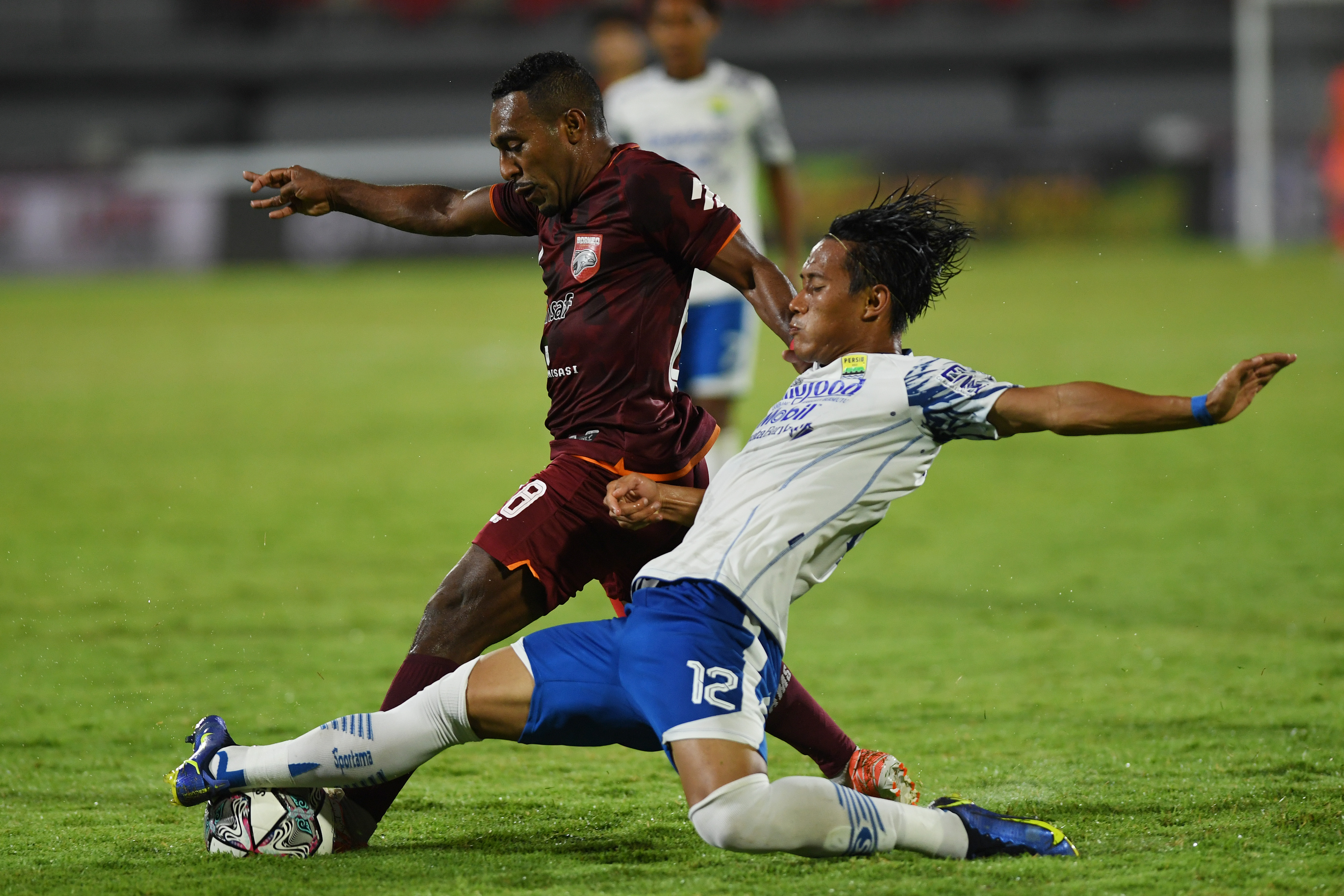  Pesepak bola Persib Bandung Henhen Herdiana (kanan) berebut bola